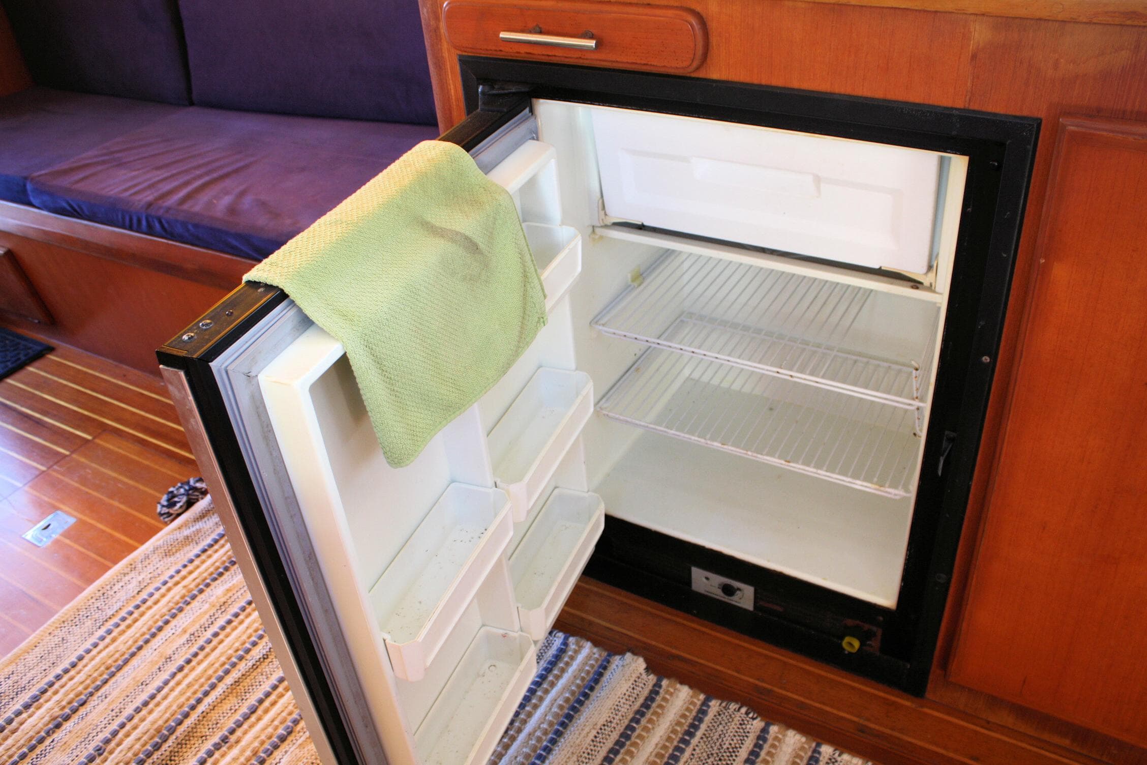 Open fridge in Island Gypsy 32 yacht, 2000 model, with a green towel on the door.
