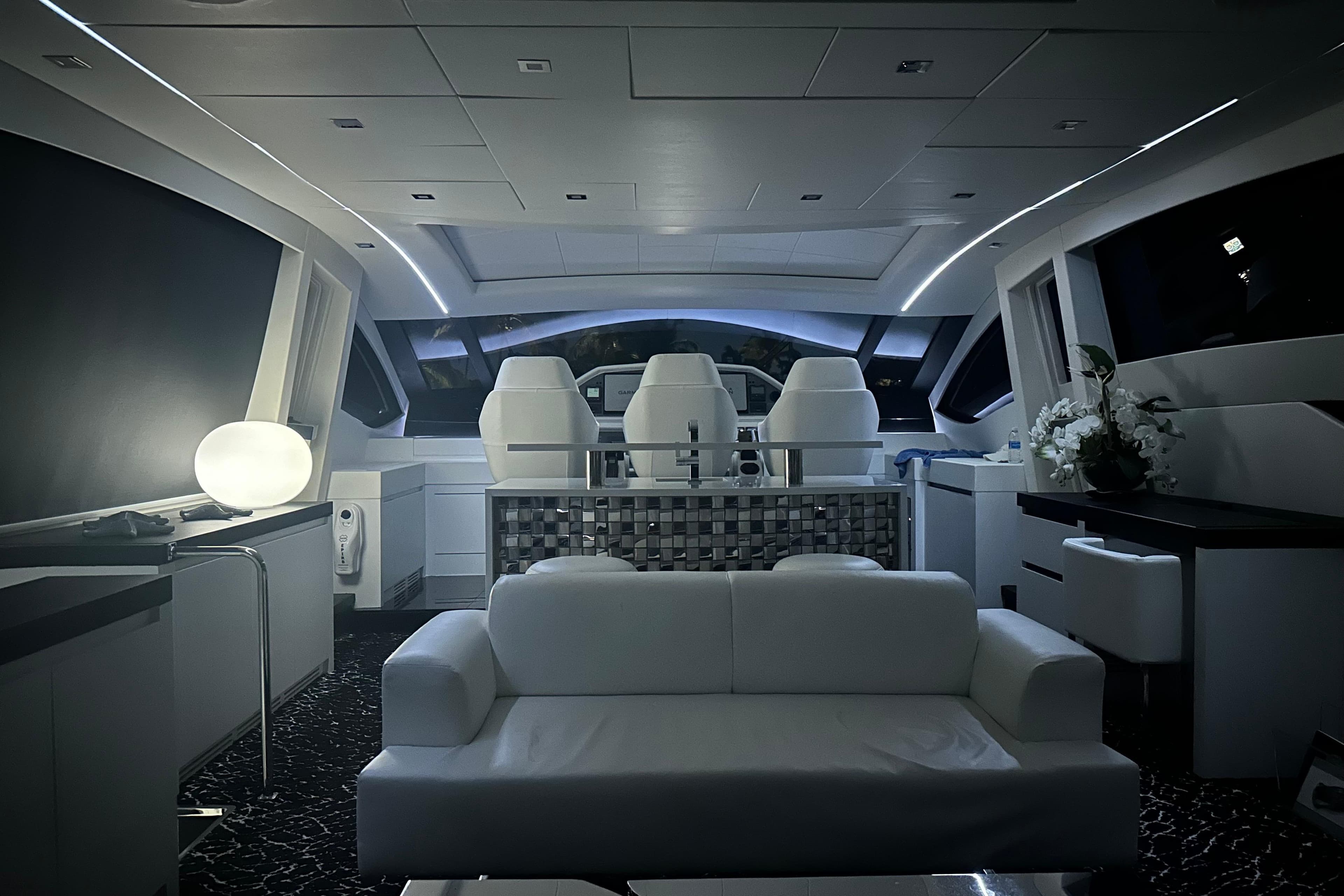 Luxurious interior of a 2010 Pershing 80 yacht with modern seating and ambient lighting.