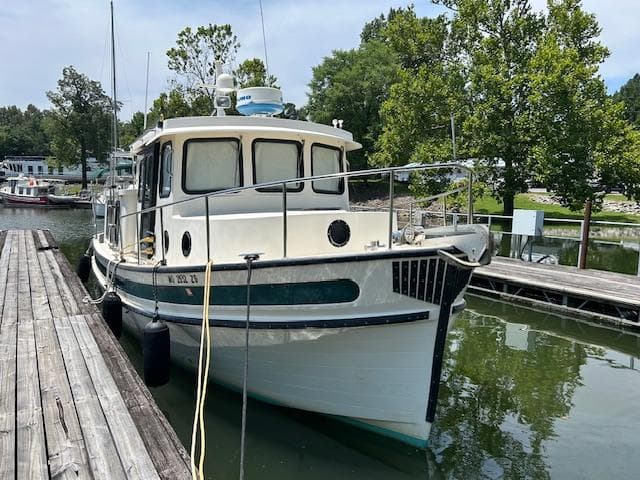 2001 Nordic Tug 32 docked in a serene marina setting.
