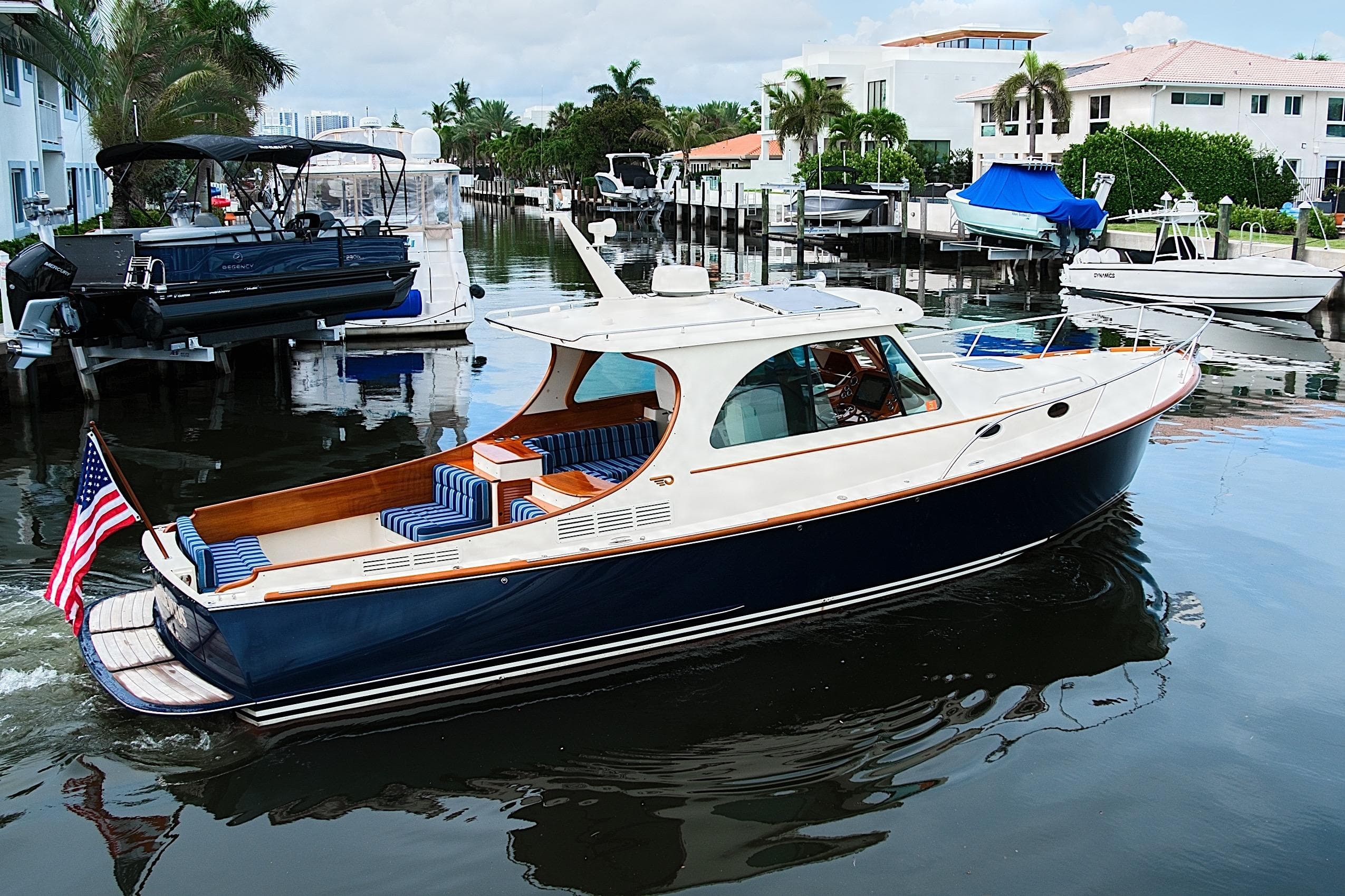 2018 Hinckley Picnic Boat 37 MKIII cruising in a scenic waterfront neighborhood.