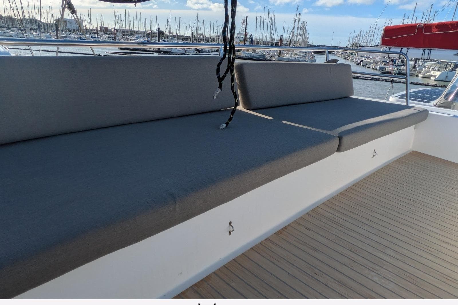 Spacious seating area on 2018 NEEL 51 yacht, docked at marina with sailboats.