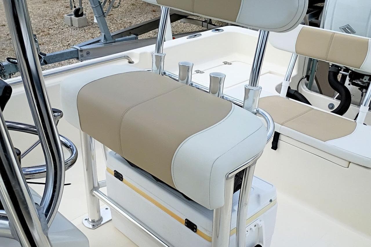 2023 Bulls Bay 2200 boat interior with beige and white seating, featuring rod holders and steering wheel.
