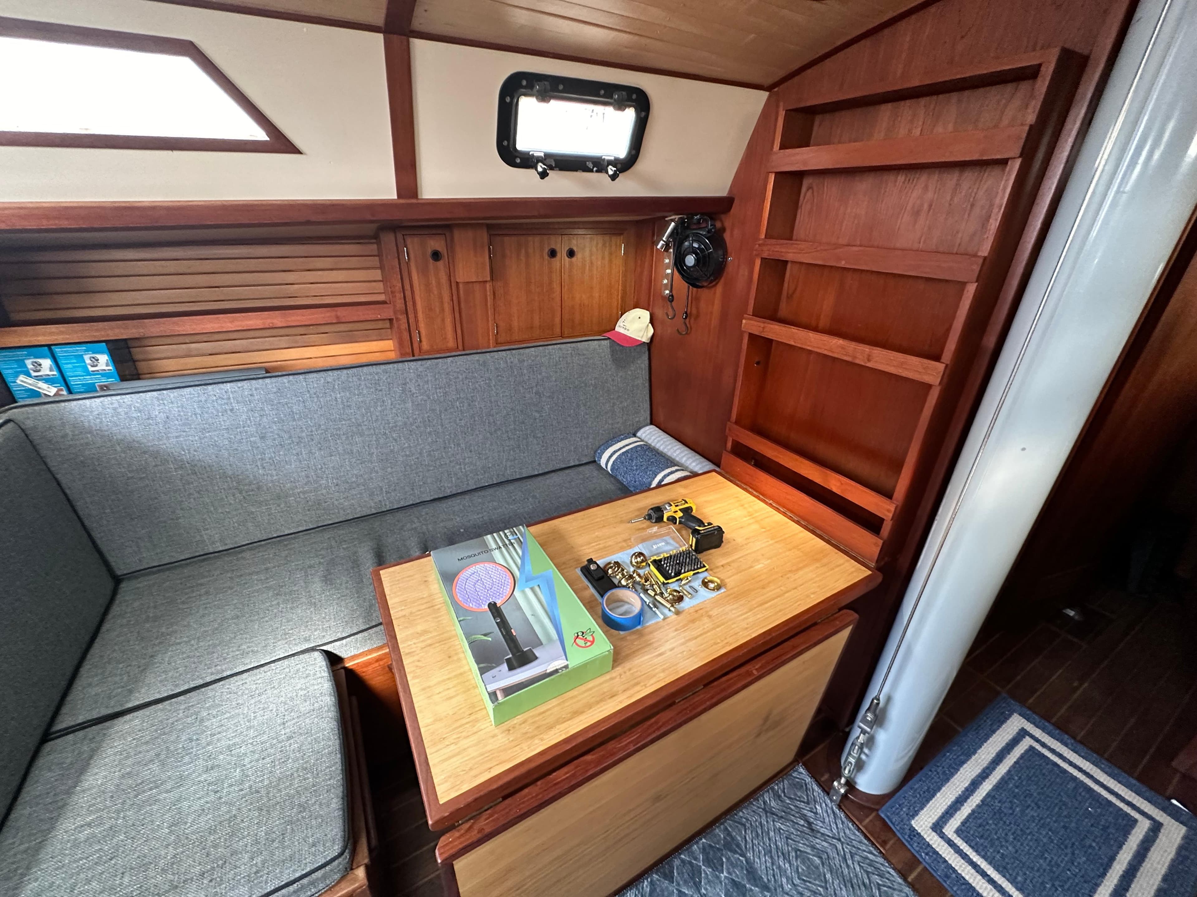 1979 Valiant 37 sailboat interior with cozy seating and wooden cabinetry.