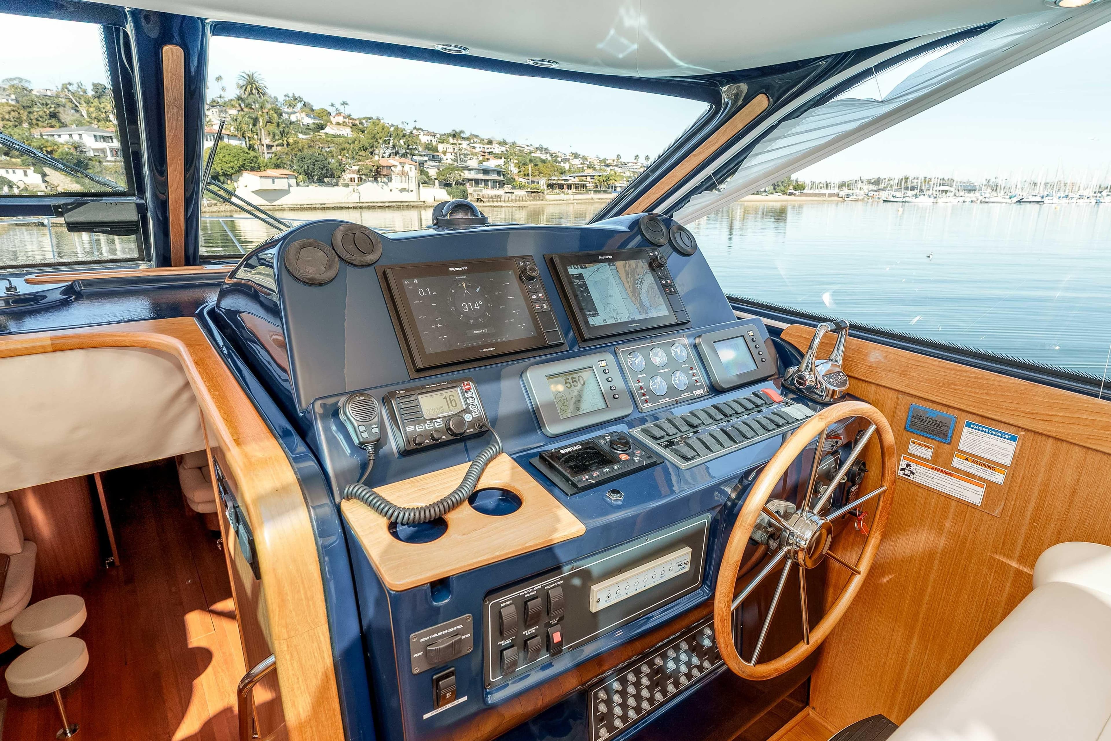Helm of 2006 Tiara Yachts 5200 Sovran Salon with navigation equipment and wooden steering wheel.