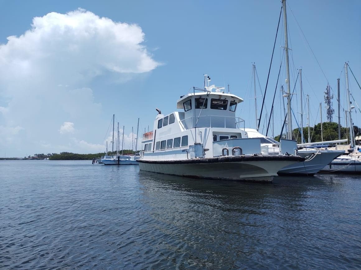 White 2012 Ferry 150 passenger boat docked in a marina on a sunny day.