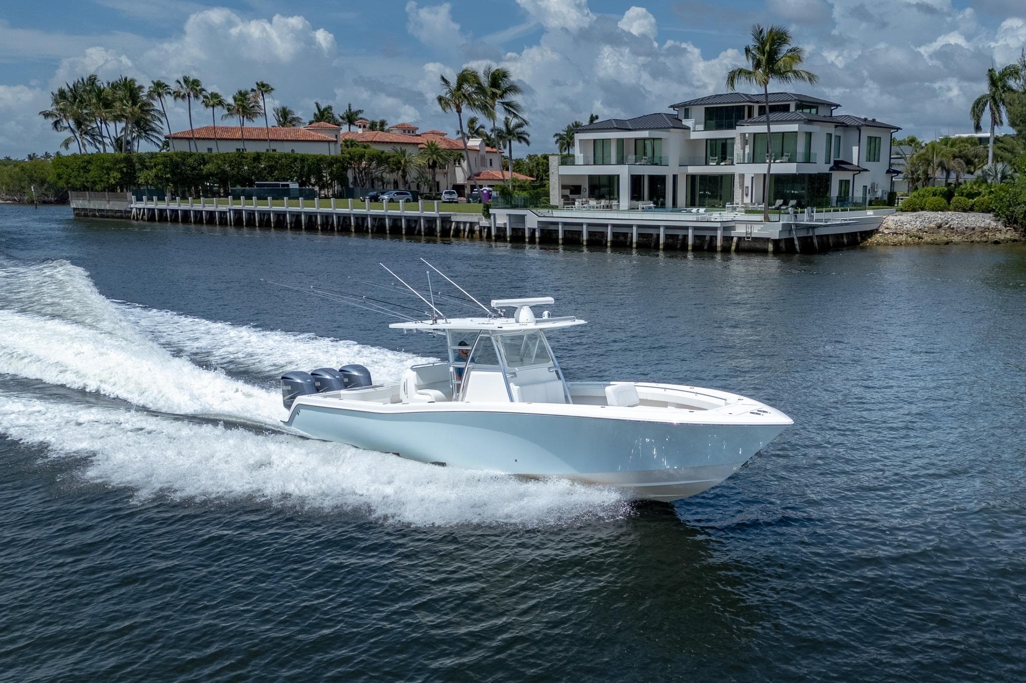 2017 Invincible 39 Open Fisherman boat cruising near luxury waterfront homes.