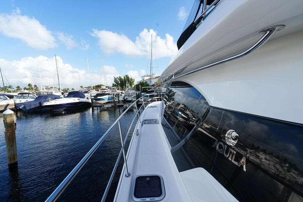 2023 Aquila 44 Yacht docked at marina under clear blue sky.