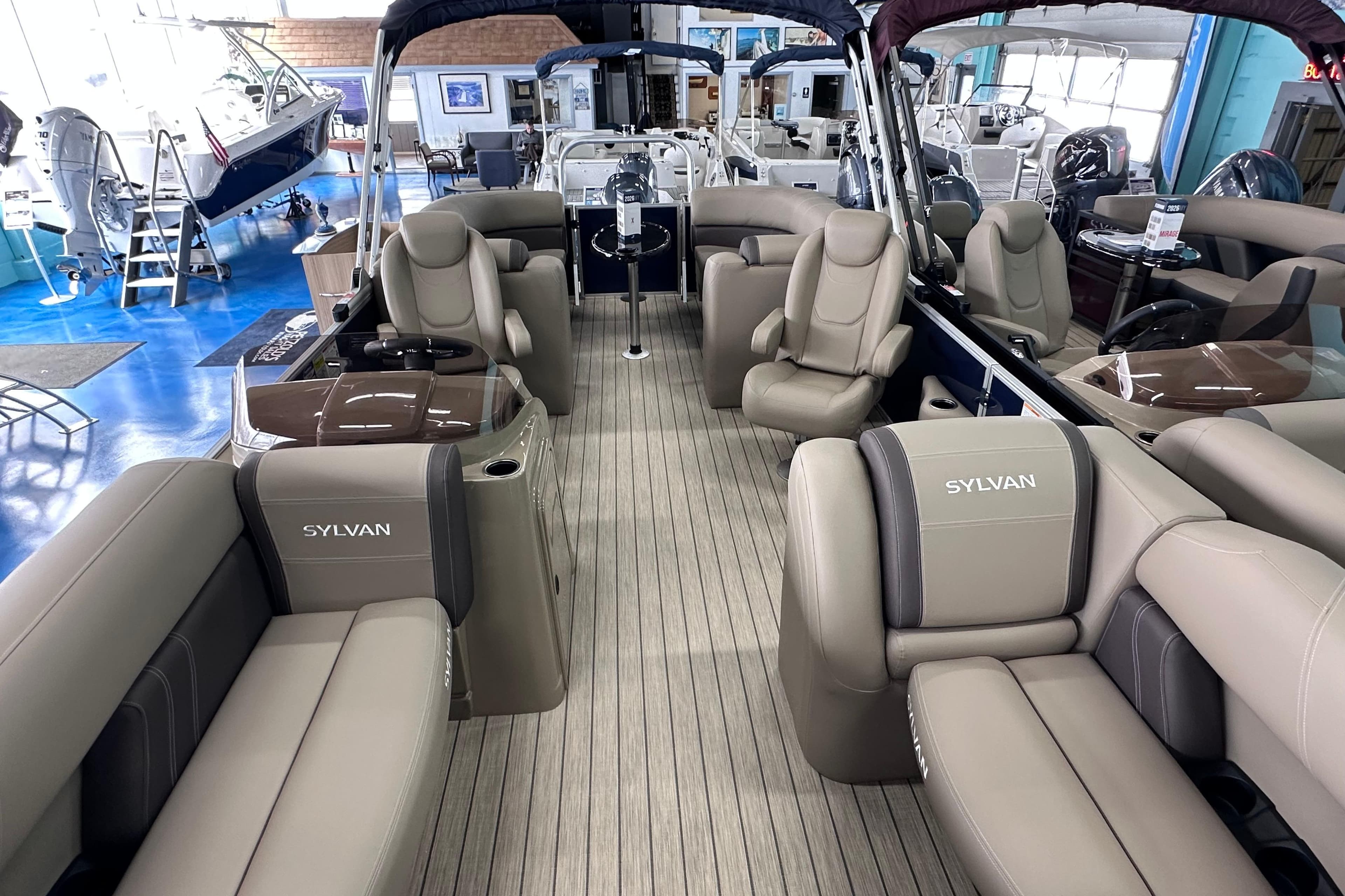2026 Sylvan Mirage 8522 LZ pontoon boat interior with luxurious seating in showroom.