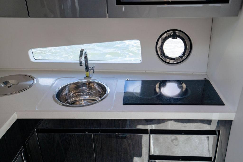 Modern kitchen area in 2022 Schaefer 400 Sport yacht with sink and stove.