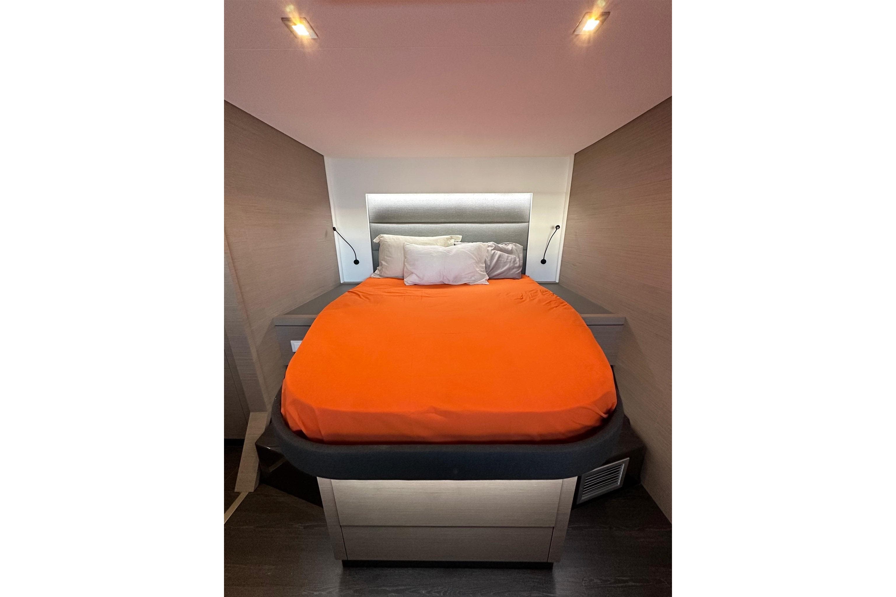 Cozy bedroom in 2021 Fountaine Pajot Saona 47 yacht with orange bedding.