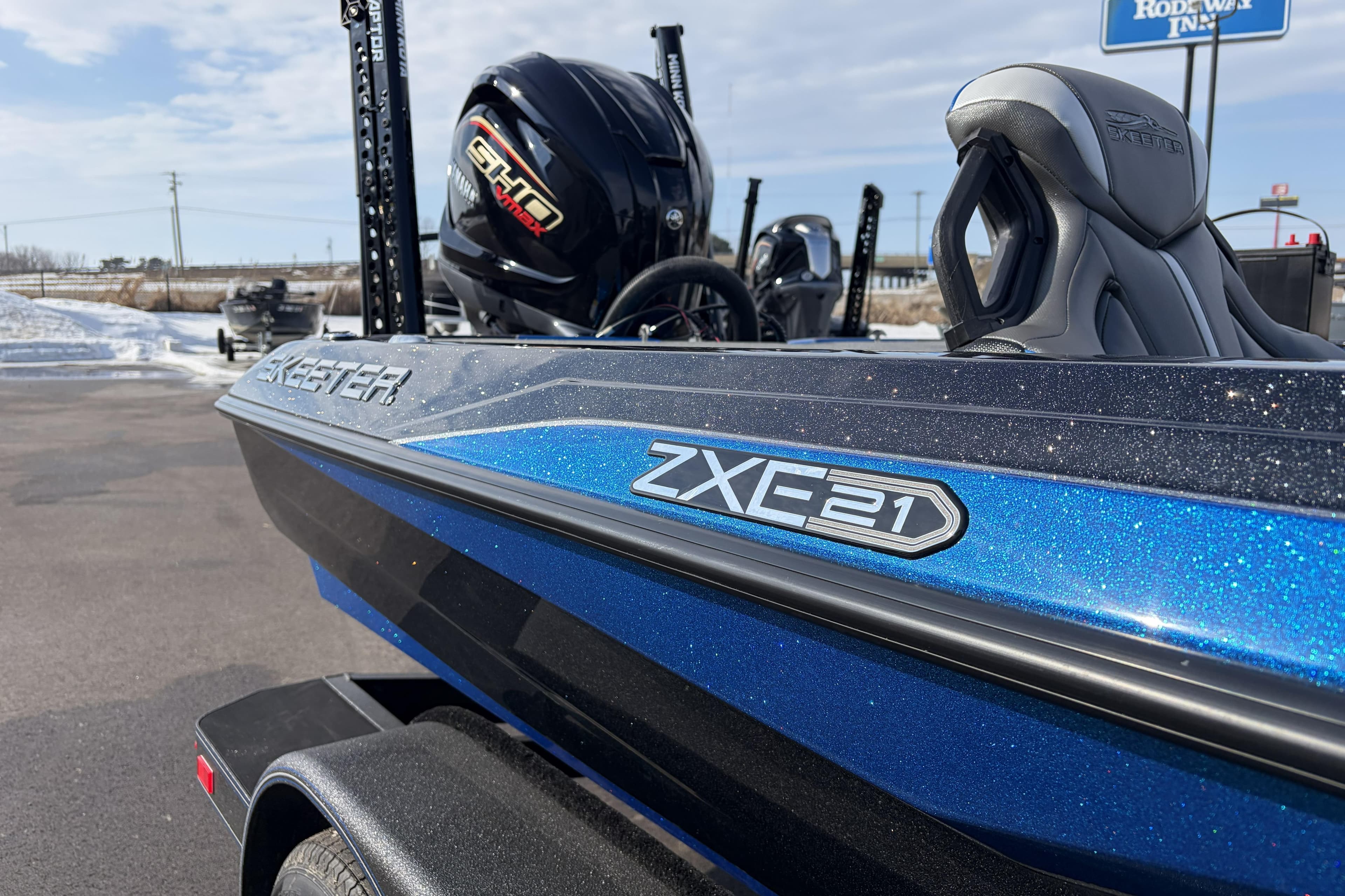 2026 Skeeter ZXE21 boat with Yamaha engine, blue and black design, parked outdoors.