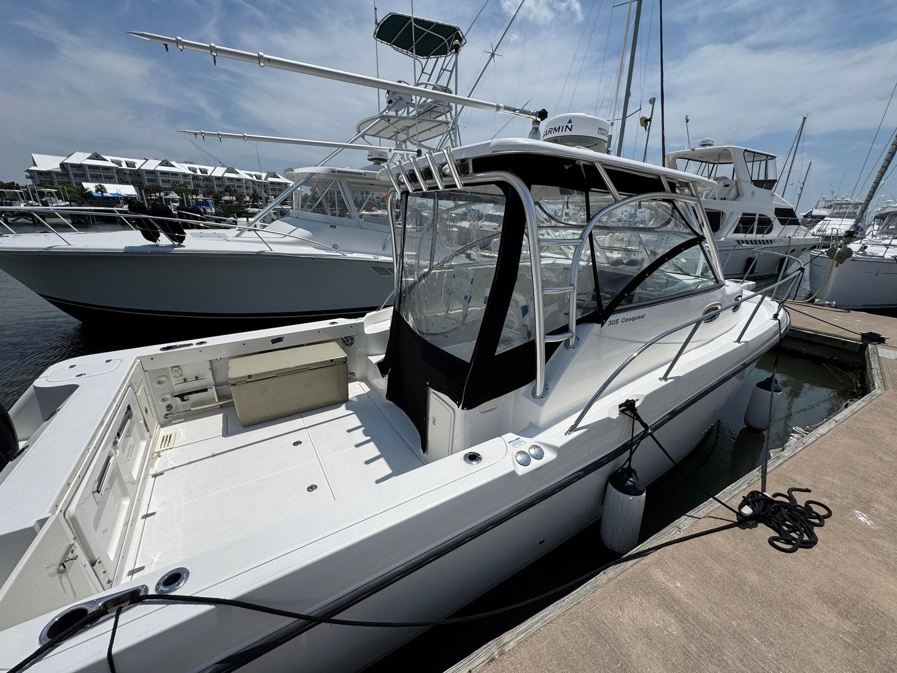 2011 Boston Whaler 305 Conquest docked at marina under clear skies.