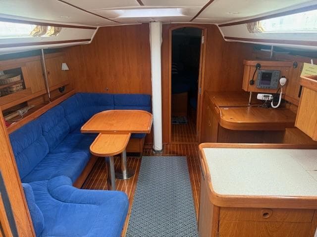 Interior of 2003 Wauquiez Centurion 45s sailboat with blue seating and wooden finishes.