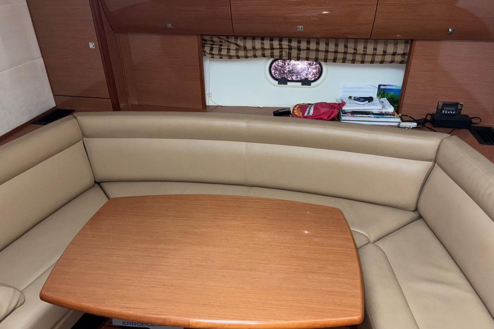 Luxurious interior of 2009 Jeanneau Prestige 42 S yacht with beige seating and wooden table.