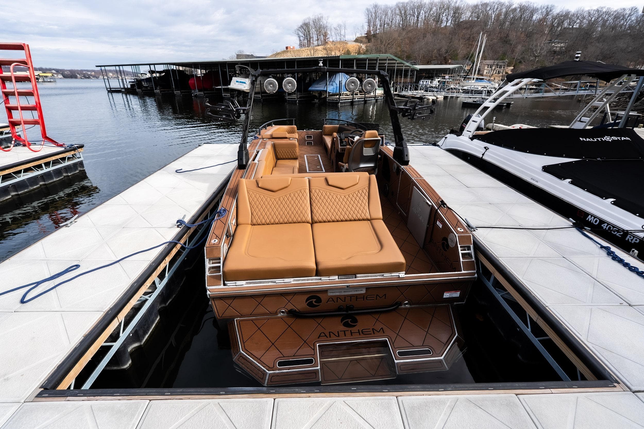 Luxury Anthem Assault ST23 boat docked at marina, showcasing sleek design and comfortable seating.