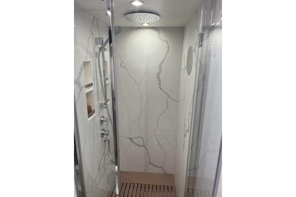 Luxurious shower in 2020 Azimut Fly 72 yacht with marble walls and modern fixtures.
