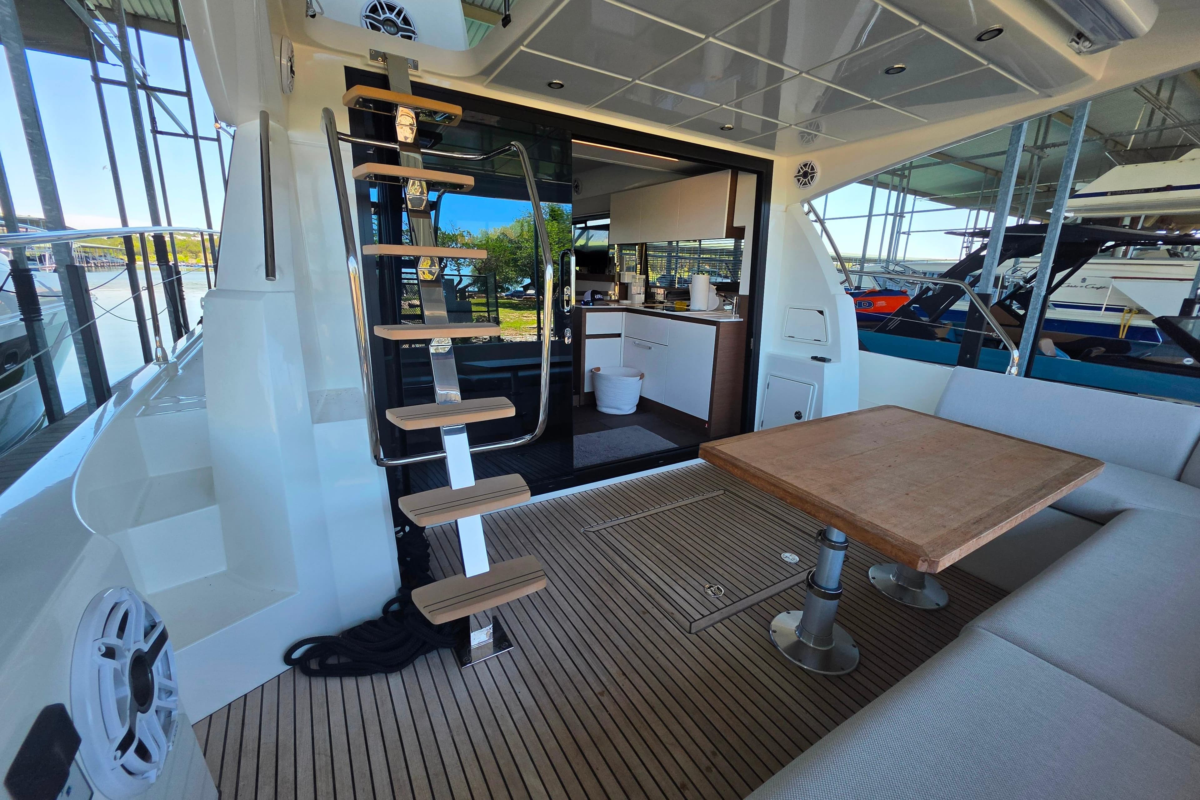 Prestige 460 yacht interior, featuring modern kitchen, wooden table, and sleek staircase, 2025 model.
