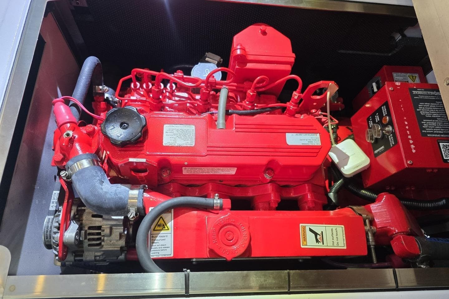 Red engine of a 2005 Oyster 56 yacht, showcasing intricate mechanical components.
