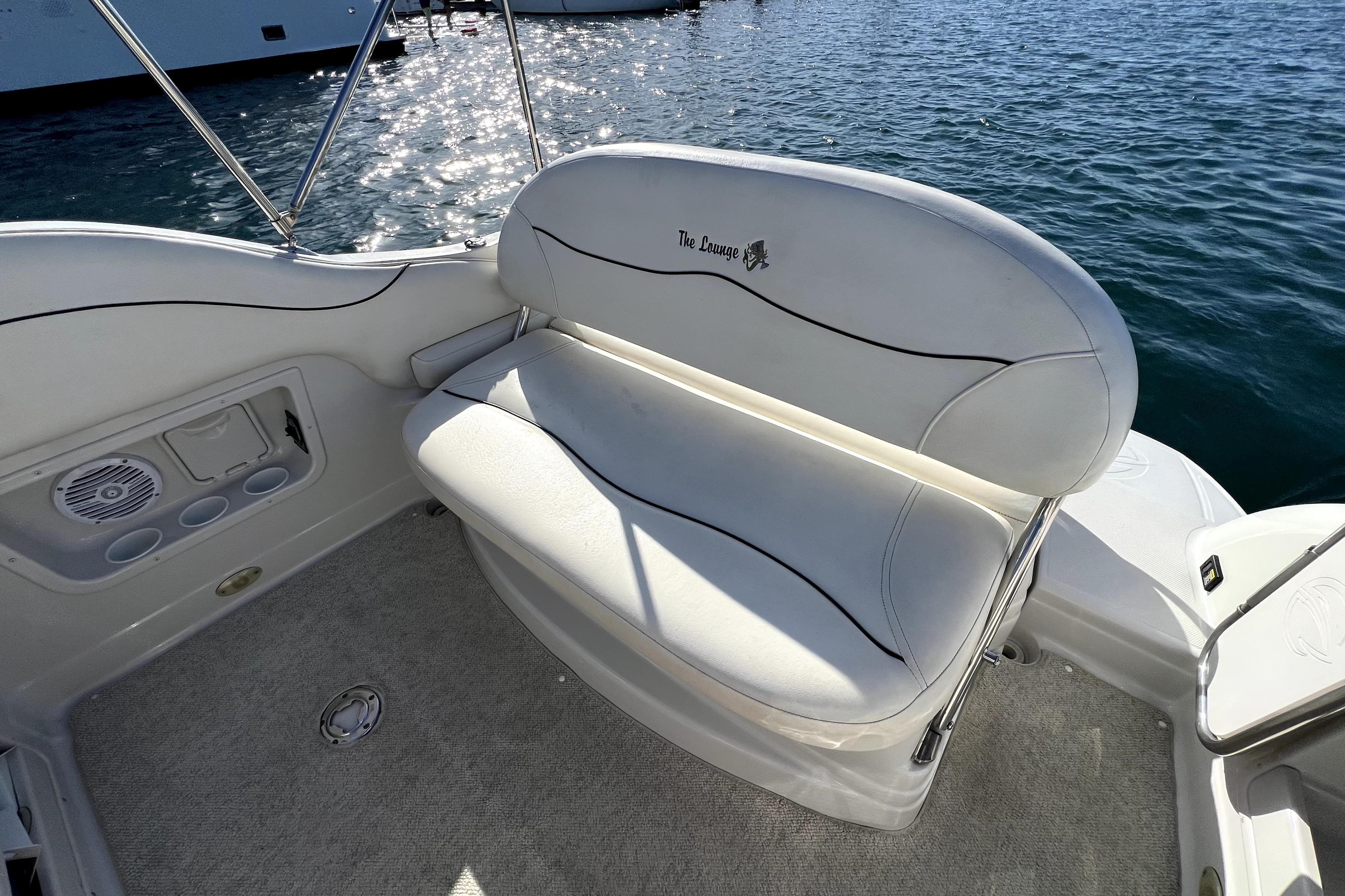 White seating area on 2004 Crownline 250 CR boat, overlooking water.