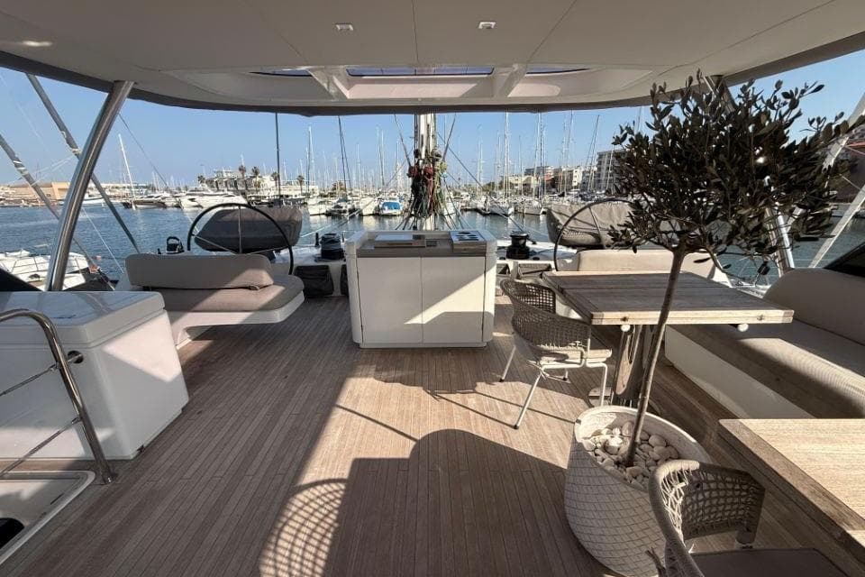 Luxurious 2018 Lagoon SEVENTY 7 yacht interior with elegant seating and marina view.