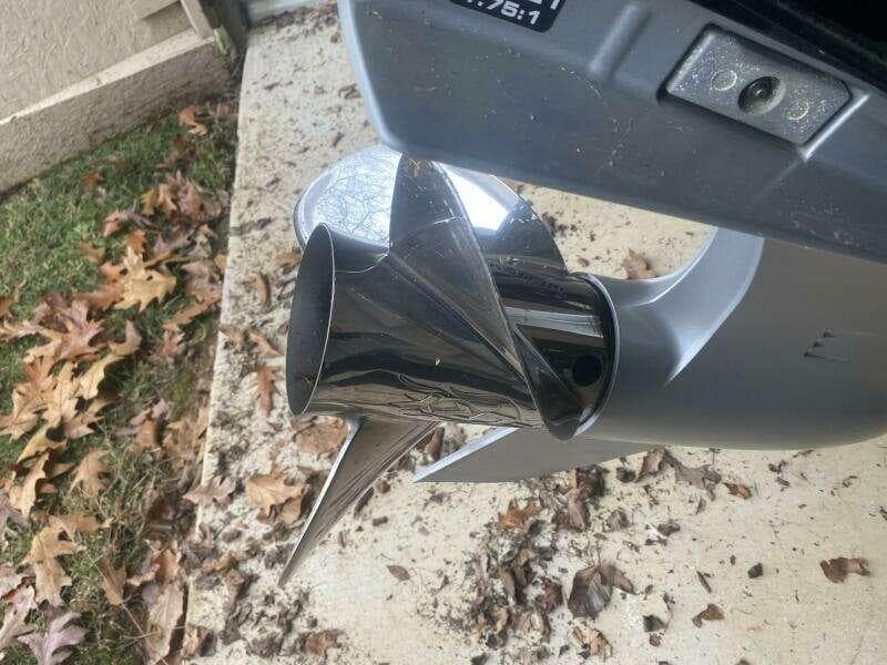 2016 Triton 20 TRX Elite boat propeller on concrete with fallen leaves.