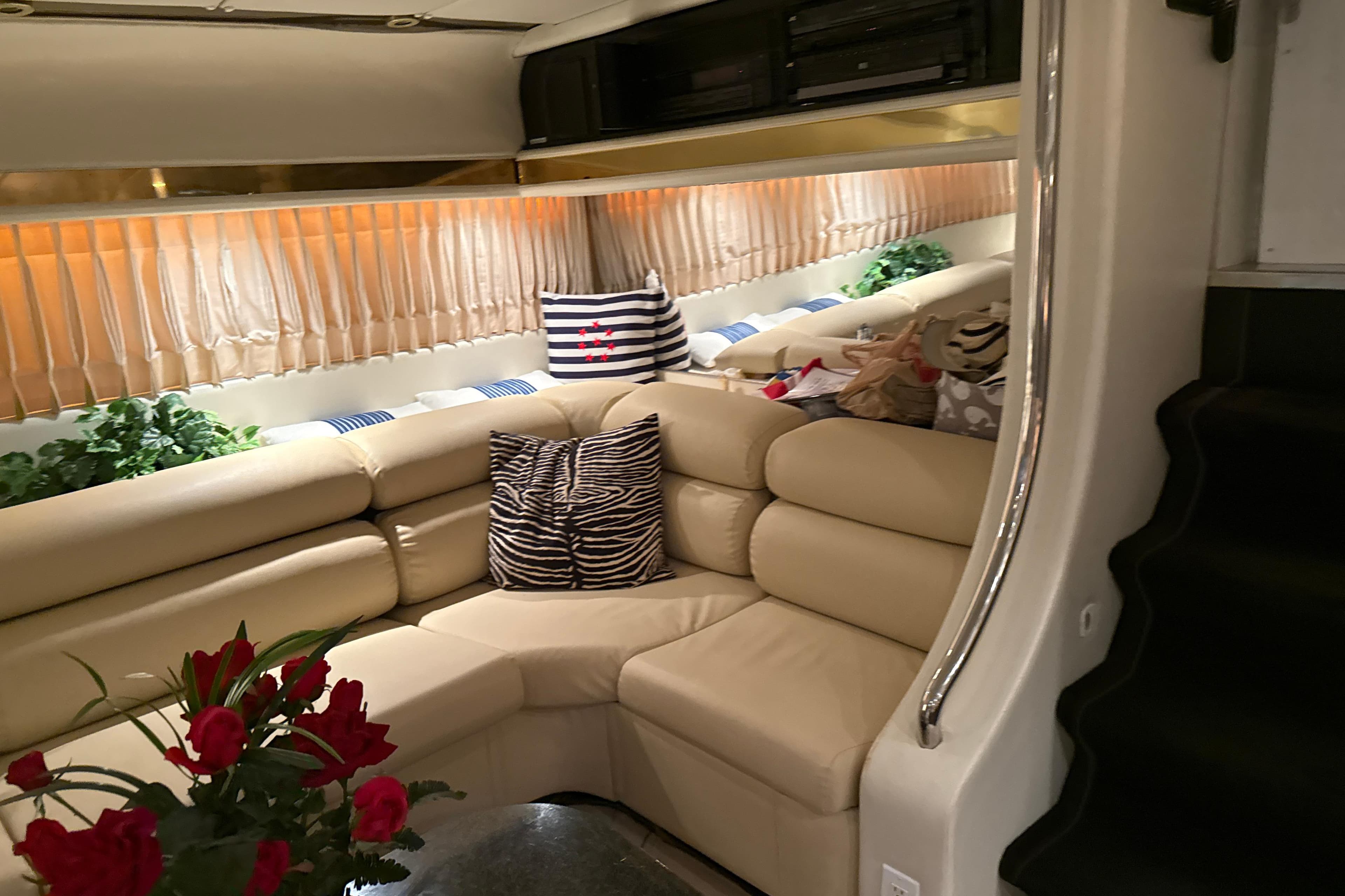 Luxurious 1999 Diaship 53 yacht interior with beige leather seating and decorative pillows.