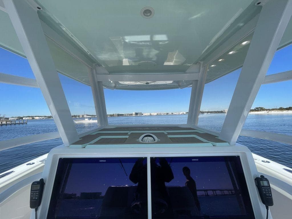 2019 Invincible 40 Catamaran helm view with dual screens and ocean backdrop.