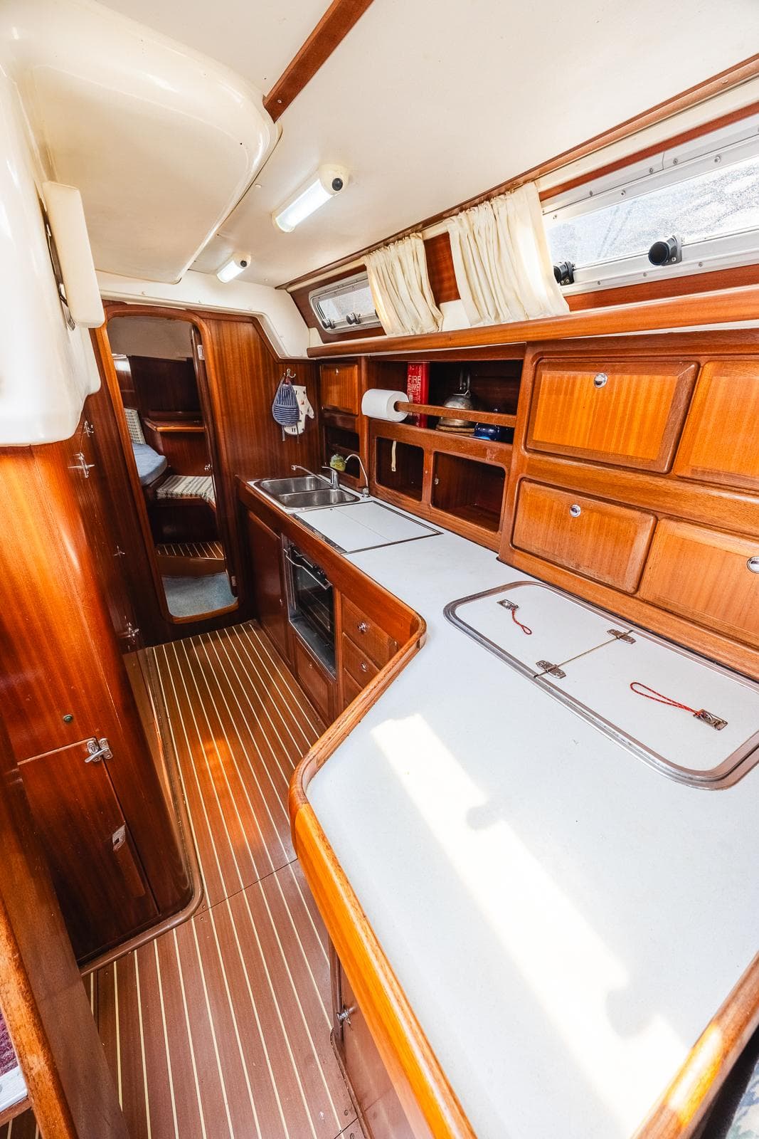 Interior of 1999 Bavaria 42 Ocean yacht with wooden cabinetry and modern amenities.