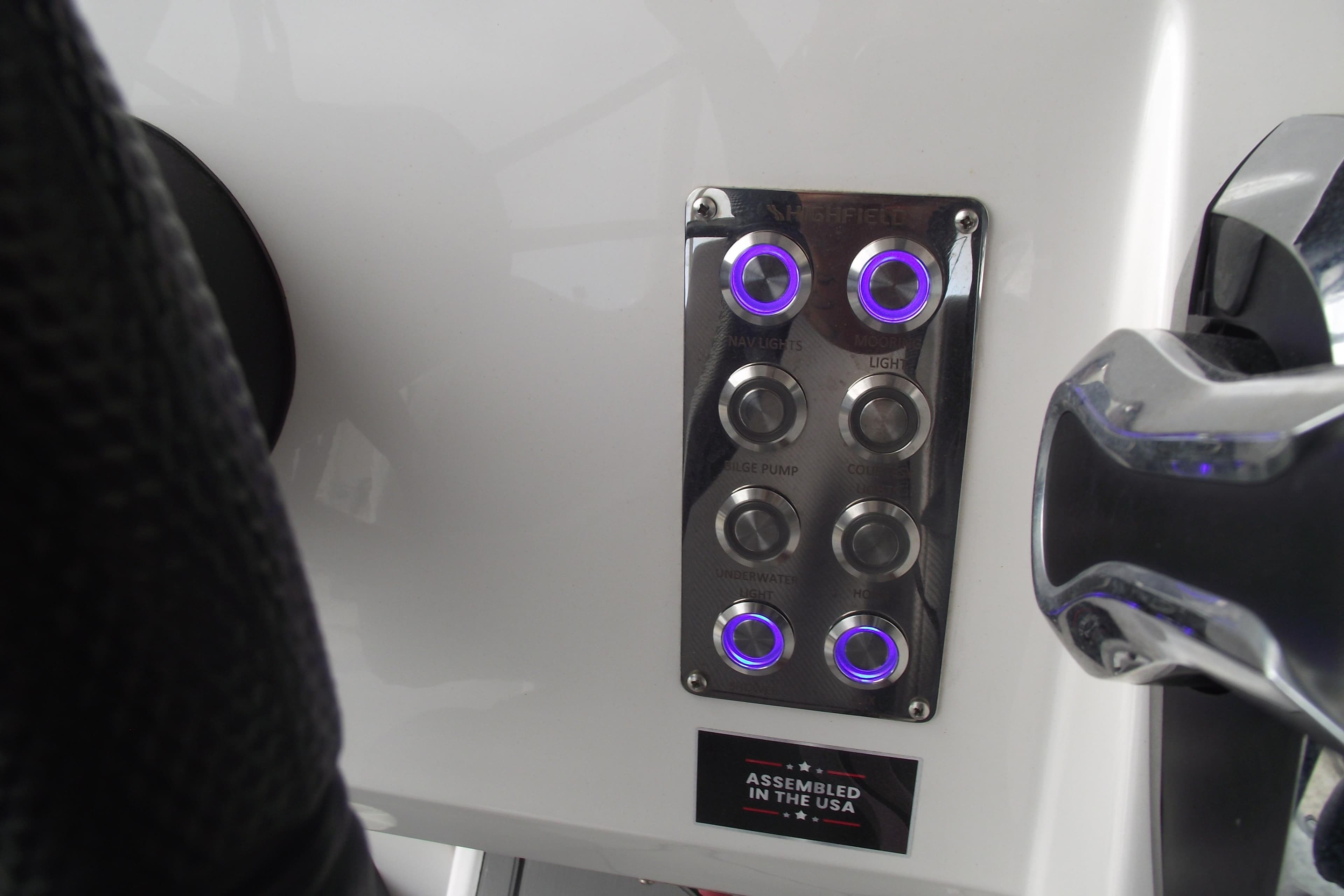 Control panel of 2024 Highfield Sport 760 boat with illuminated buttons.