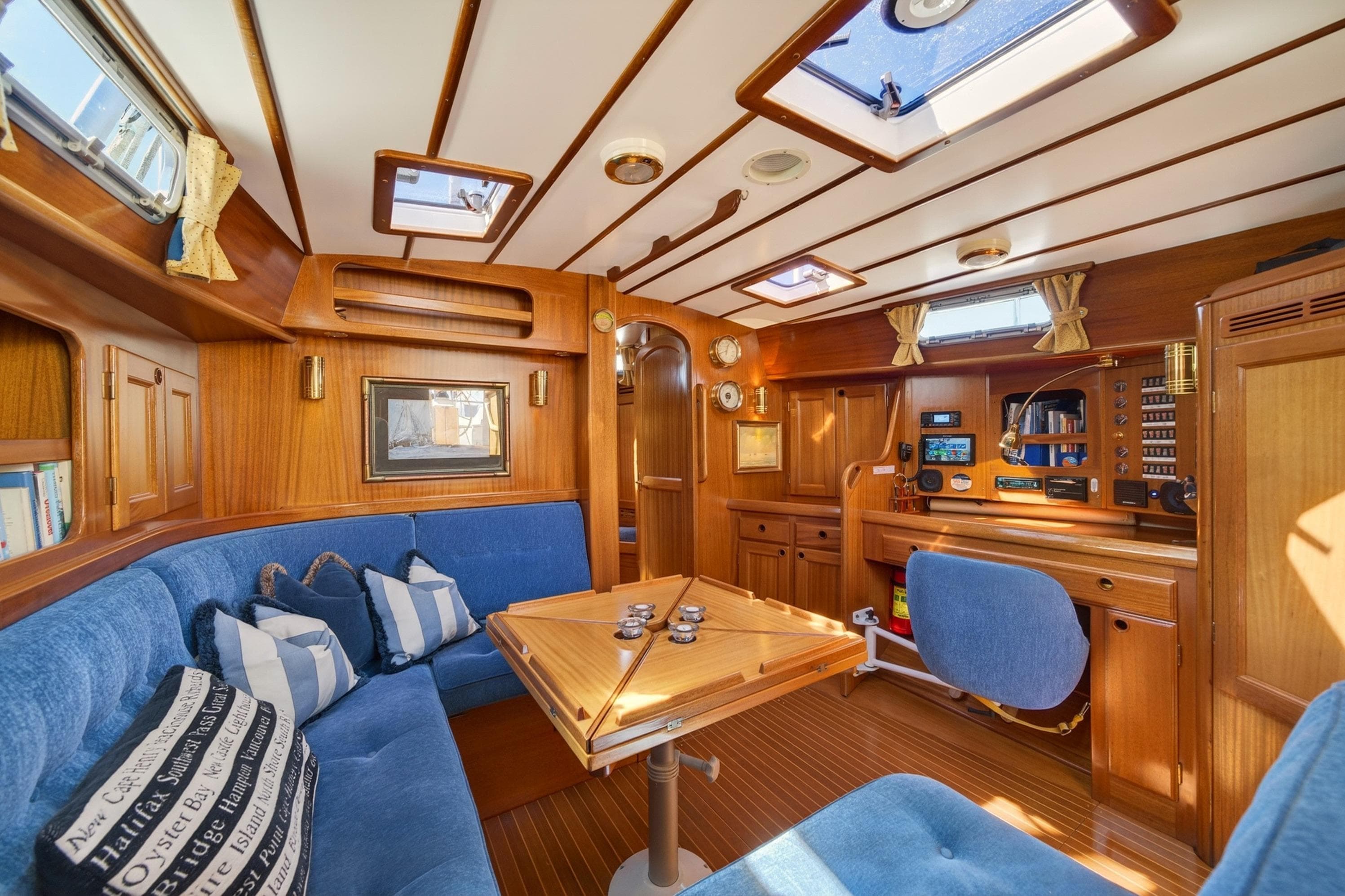 Luxurious 1997 Malo 42 yacht interior with wooden finish and blue seating.