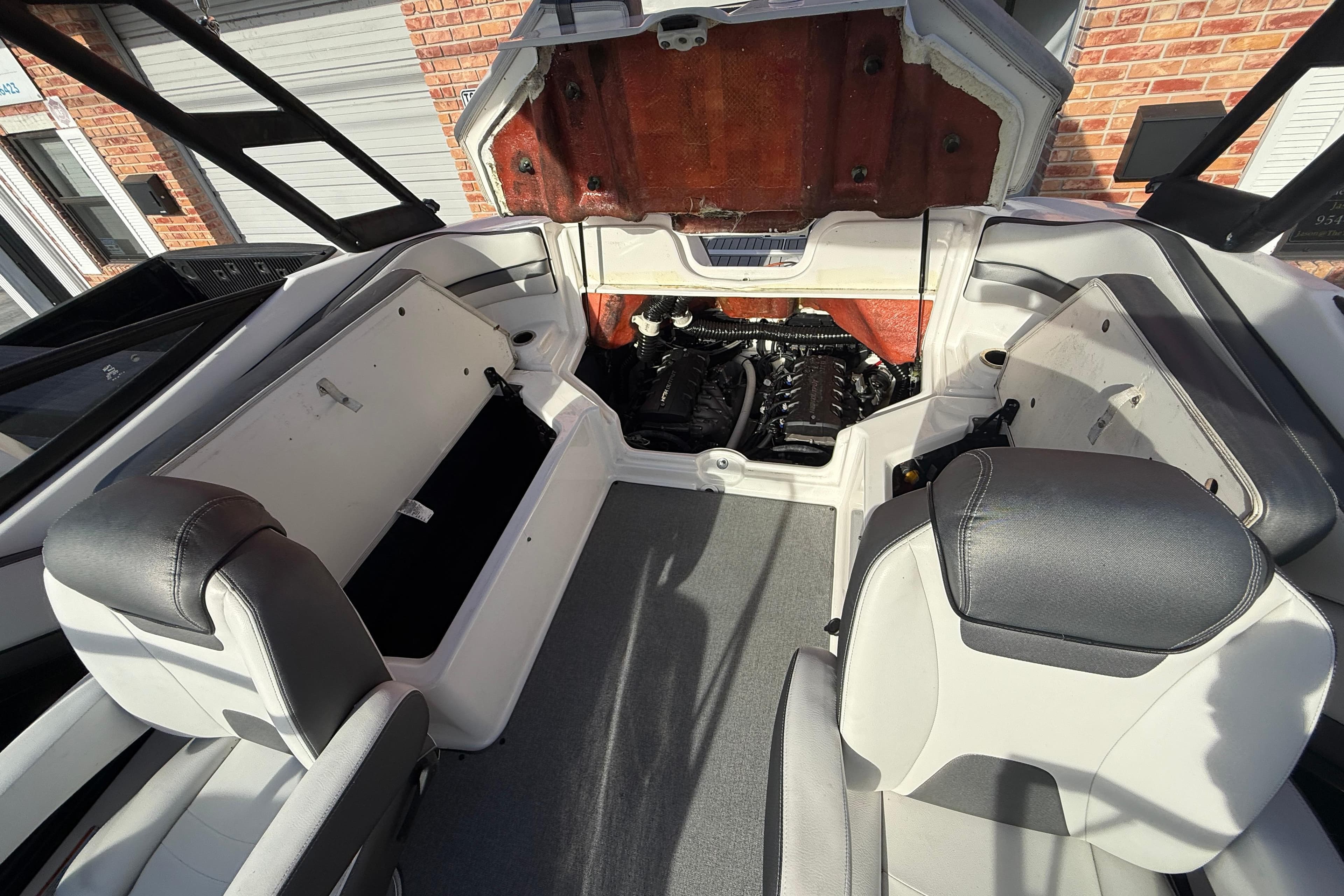 2020 Yamaha AR230 boat interior with open engine compartment, showcasing seating and storage.