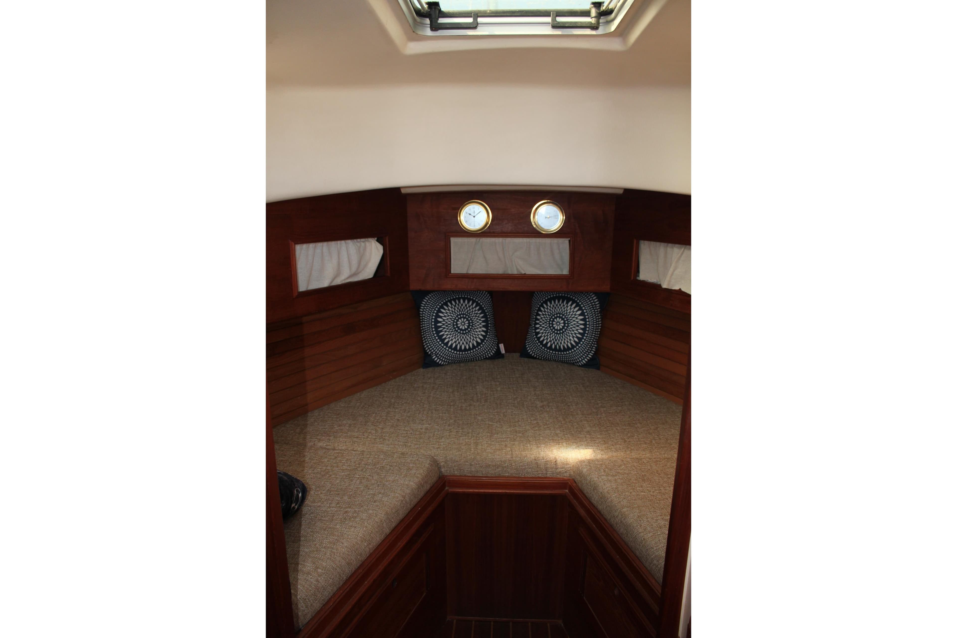Interior cabin of 1988 Cape Dory 28 Hardtop with cozy bedding and portholes.
