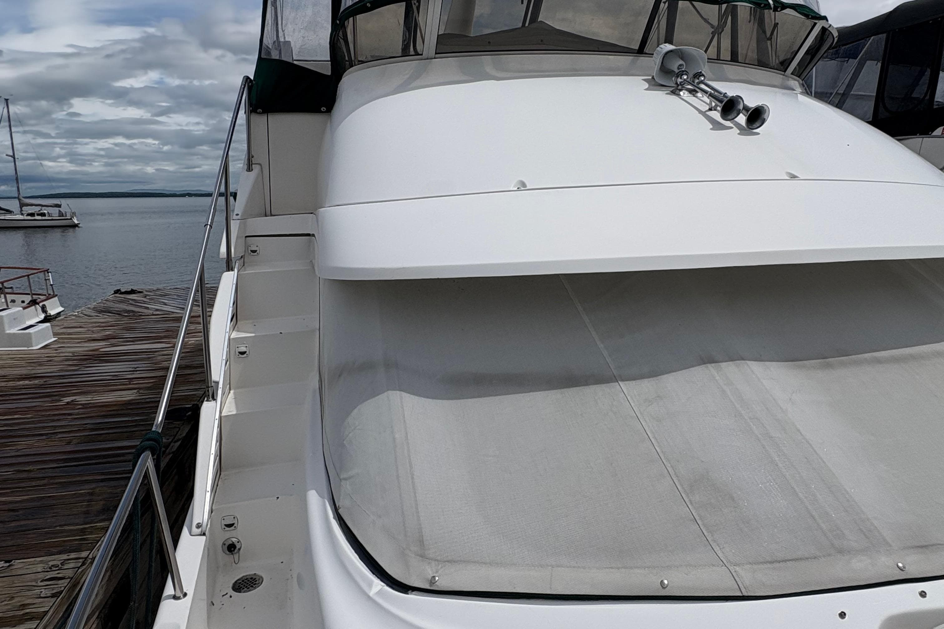 1999 Silverton 392 yacht docked by the water on a cloudy day.