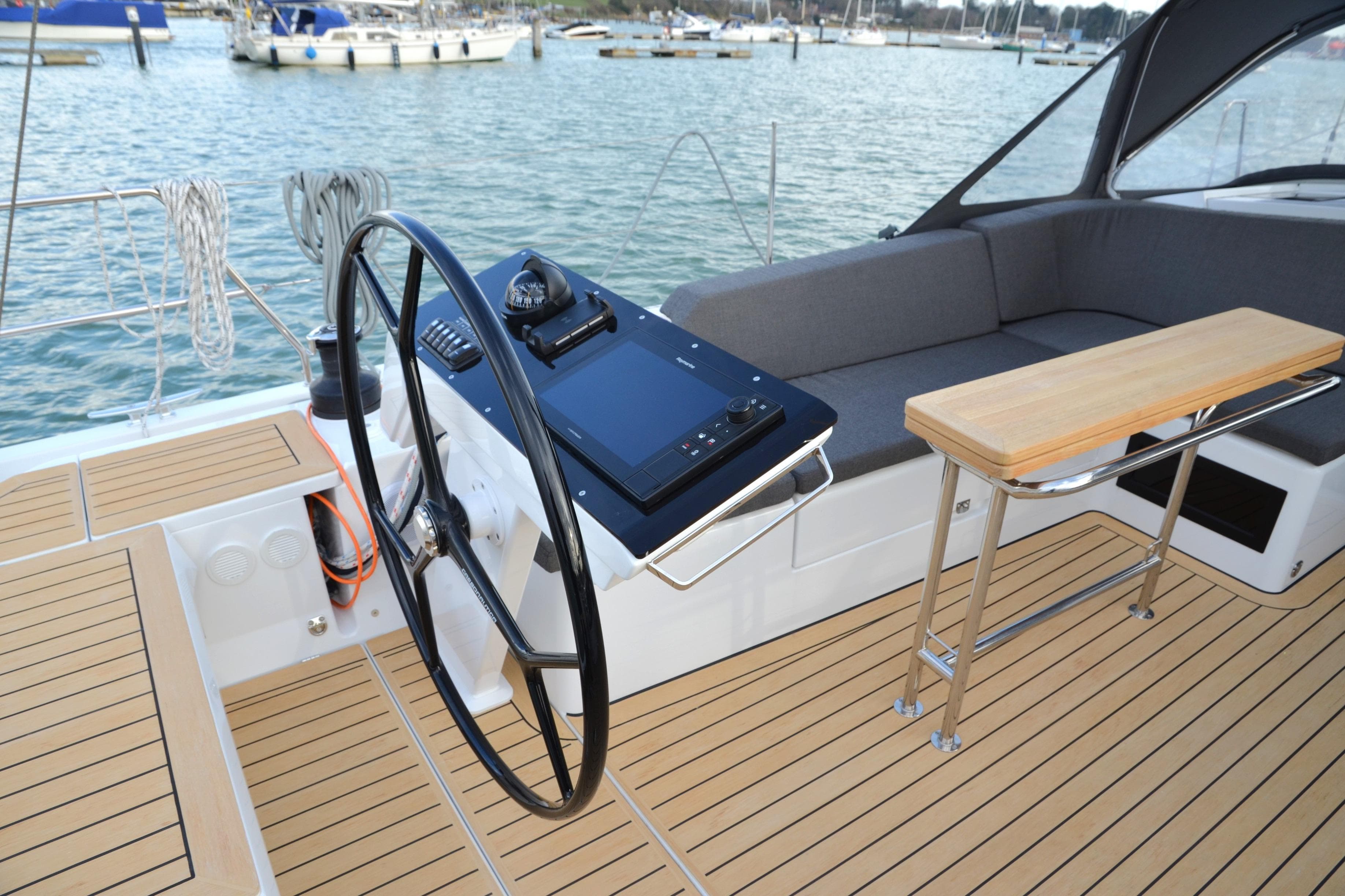 Modern Hanse 460 yacht cockpit with steering wheel and seating, docked at marina, 2025 model.