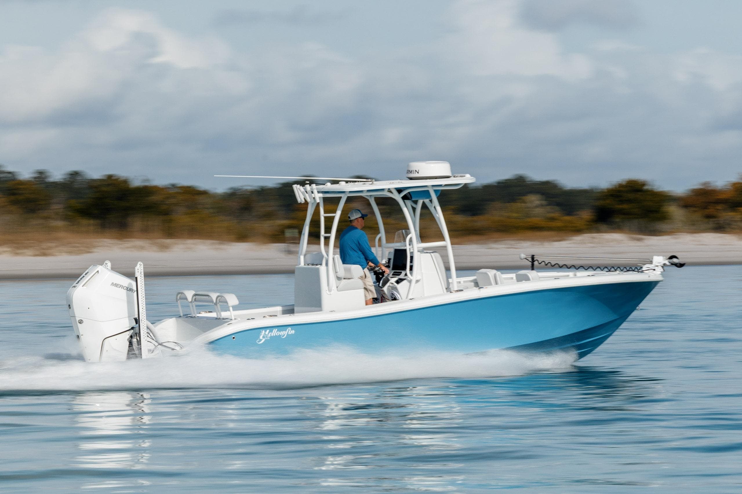 2026 Yellowfin 26 Hybrid boat cruising on calm water, side view.