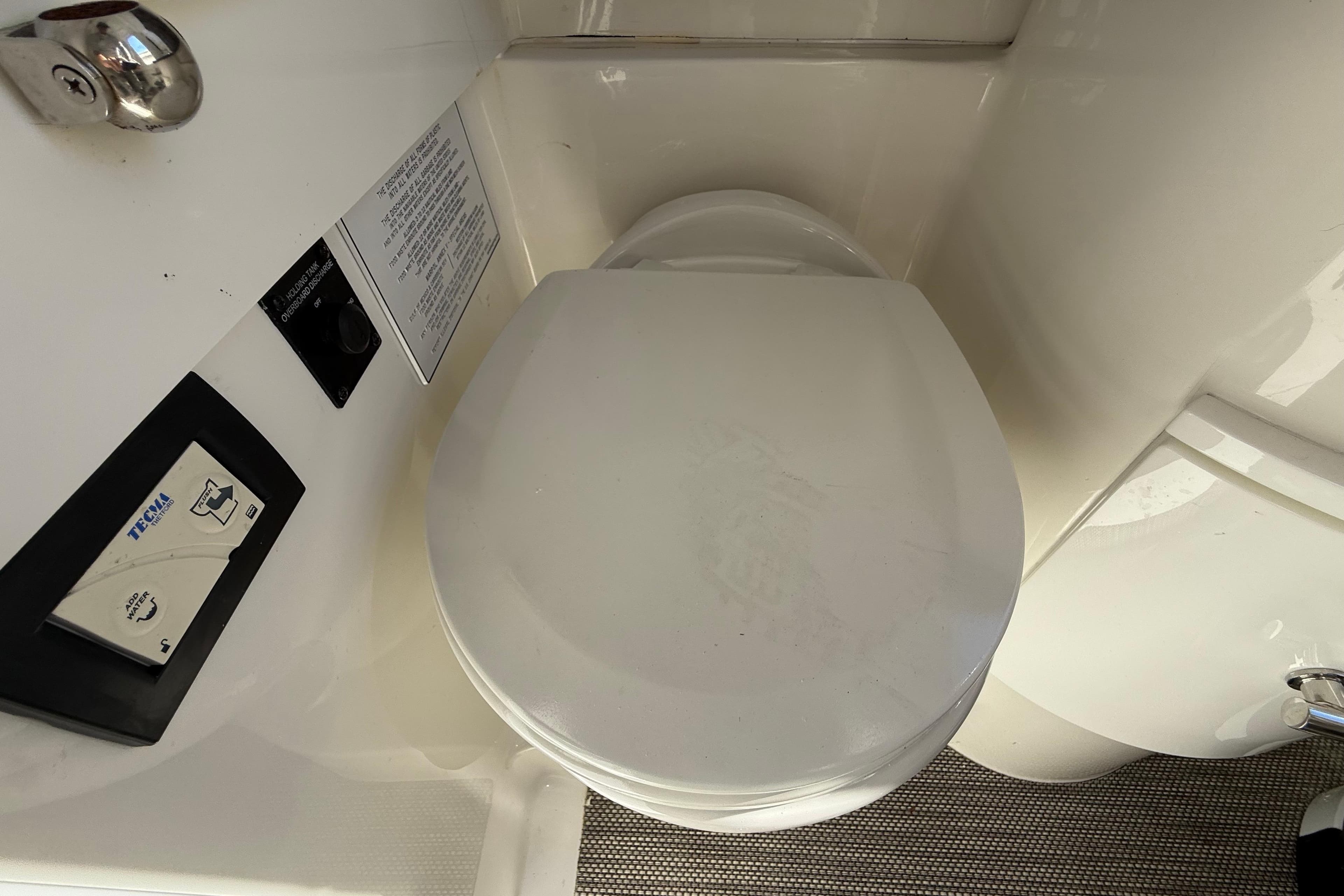 2022 Regulator 34 boat bathroom with Tecma marine toilet and control panel.