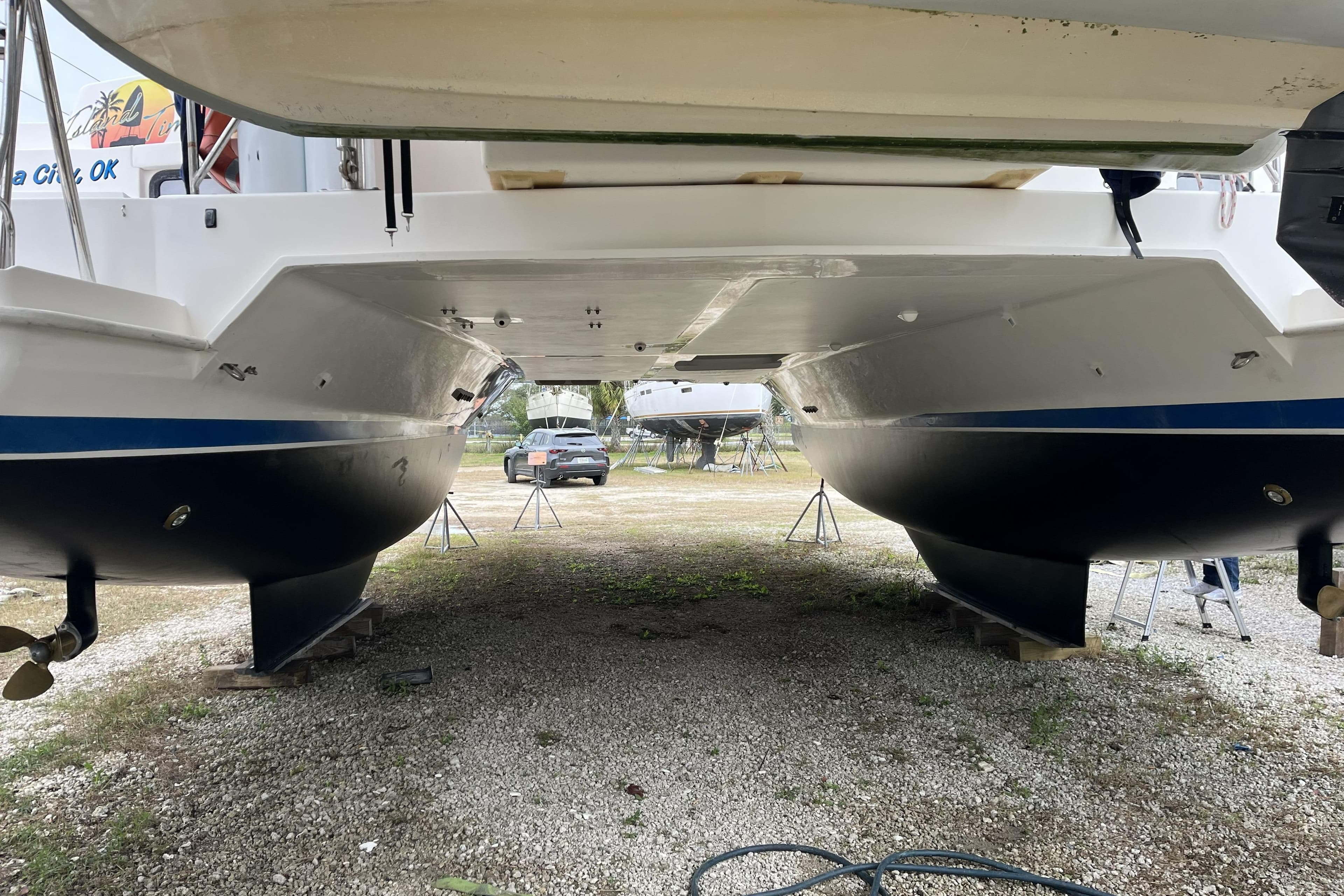 Underneath view of a 2012 Leopard 44 catamaran on dry dock, showcasing twin hulls.