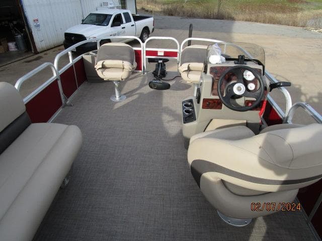 2023 Sun Tracker Bass Buggy pontoon boat interior with seating and steering console.