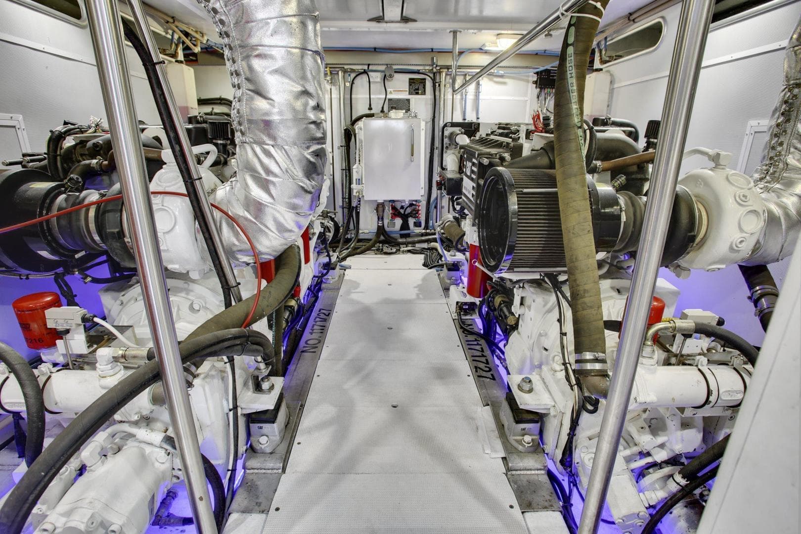 Engine room of 2027 Legend Boats 630 Skylounge, showcasing dual engines and mechanical systems.