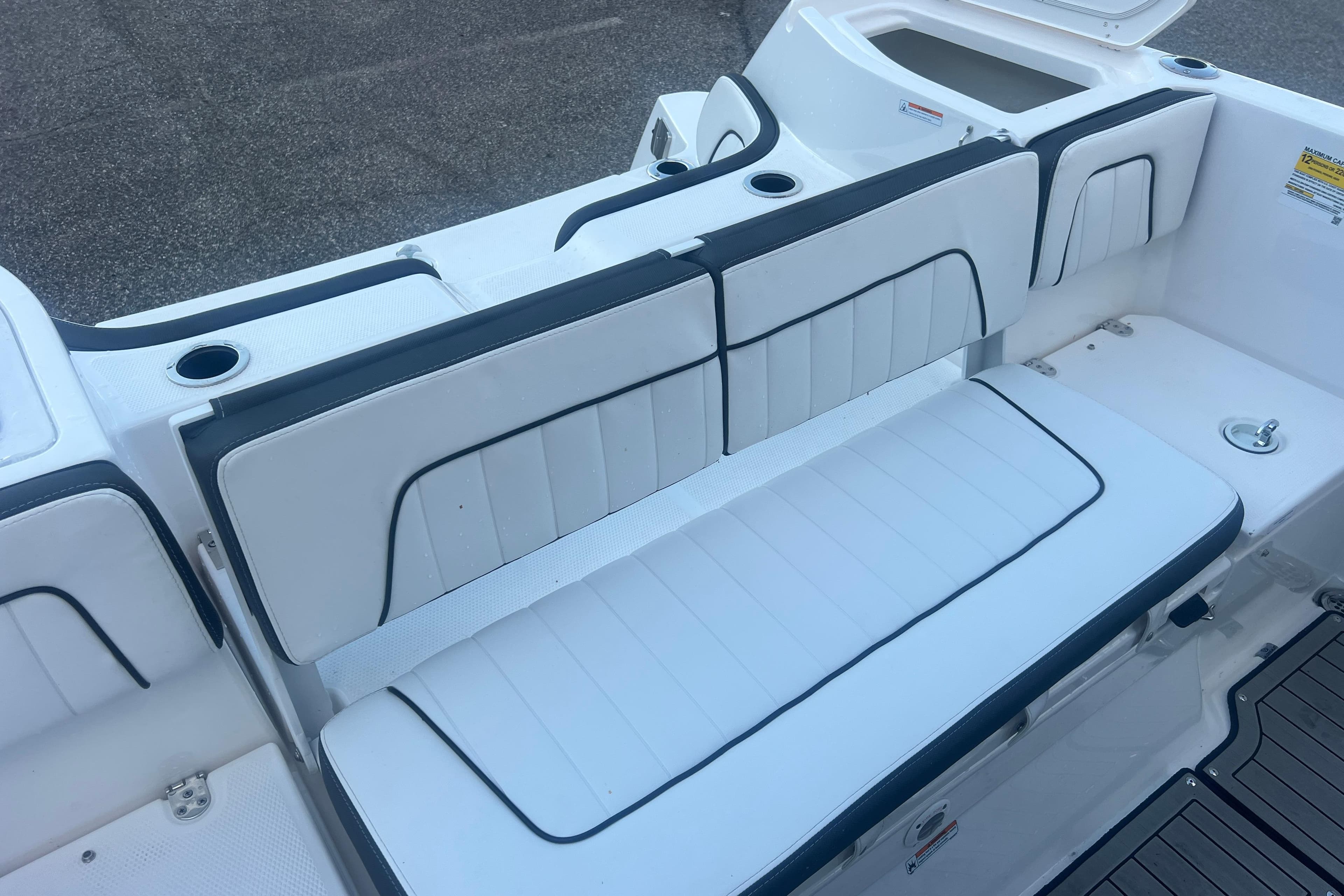 2024 Yamaha Boats 255 FSH Sport H interior seating with white upholstery and cup holders.