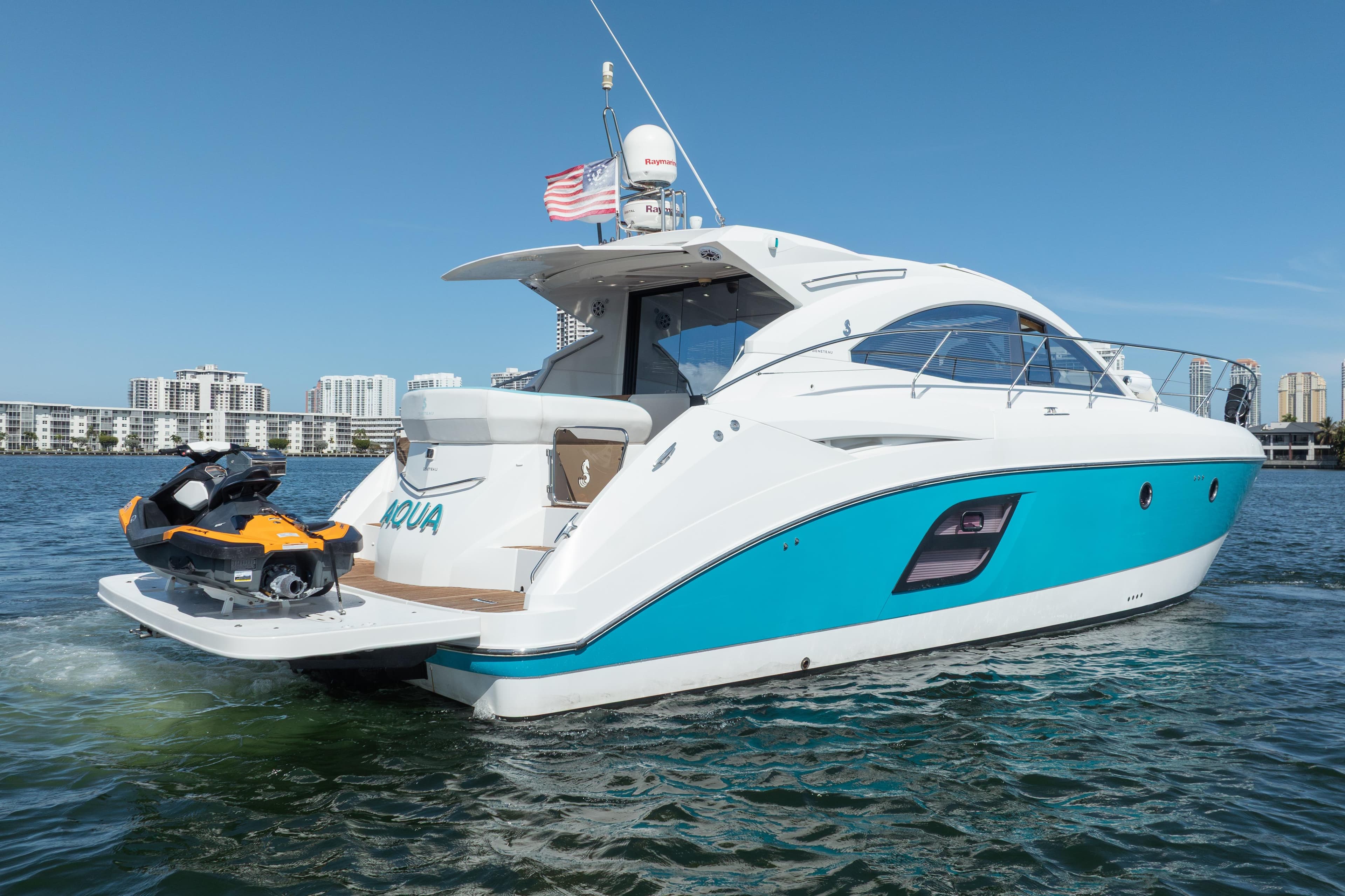 2010 Beneteau Monte Carlo 47 yacht with jet ski, cruising in sunny waters.