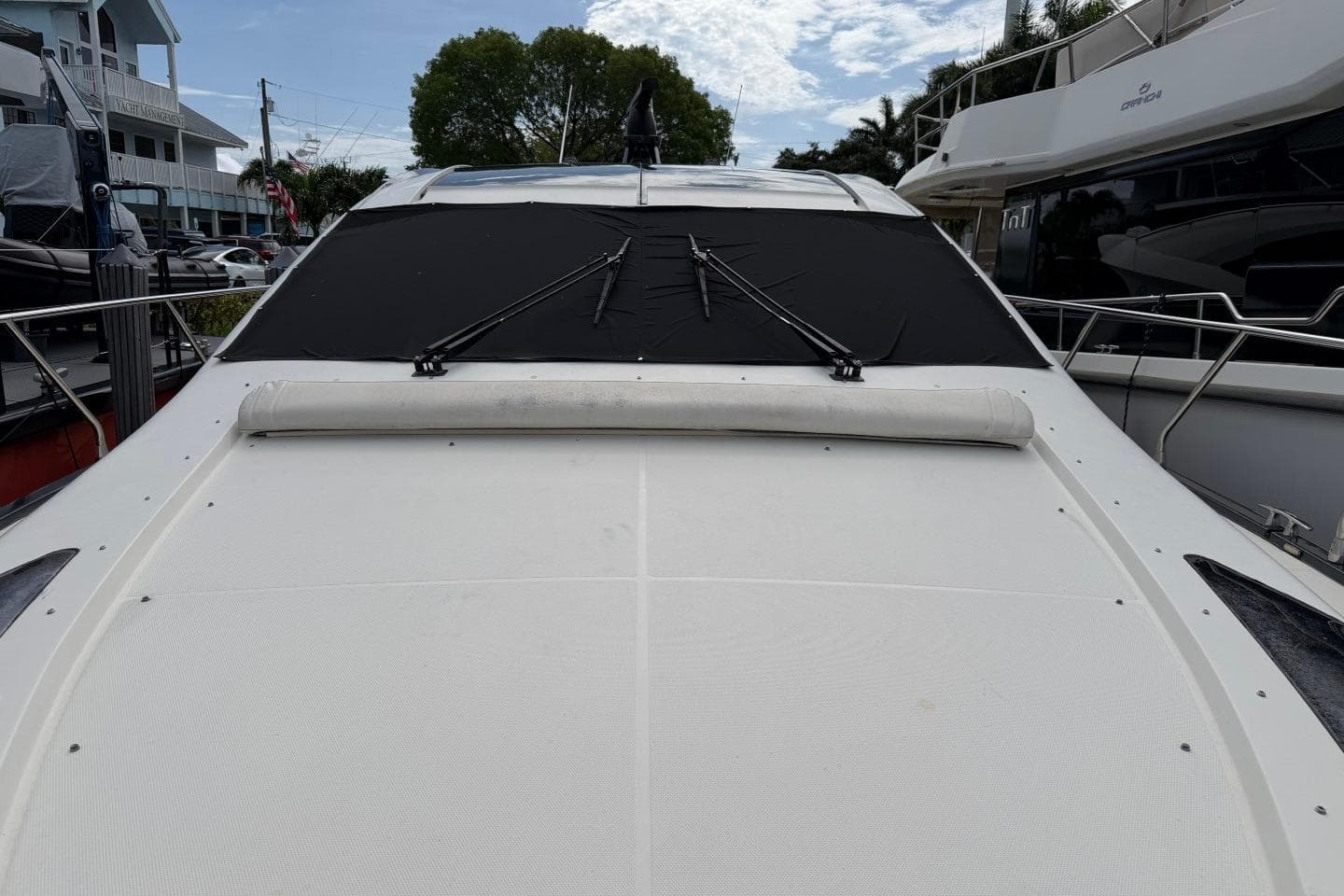 2009 Marquis 500 Sport Coupe yacht with covered windshield, docked in marina.