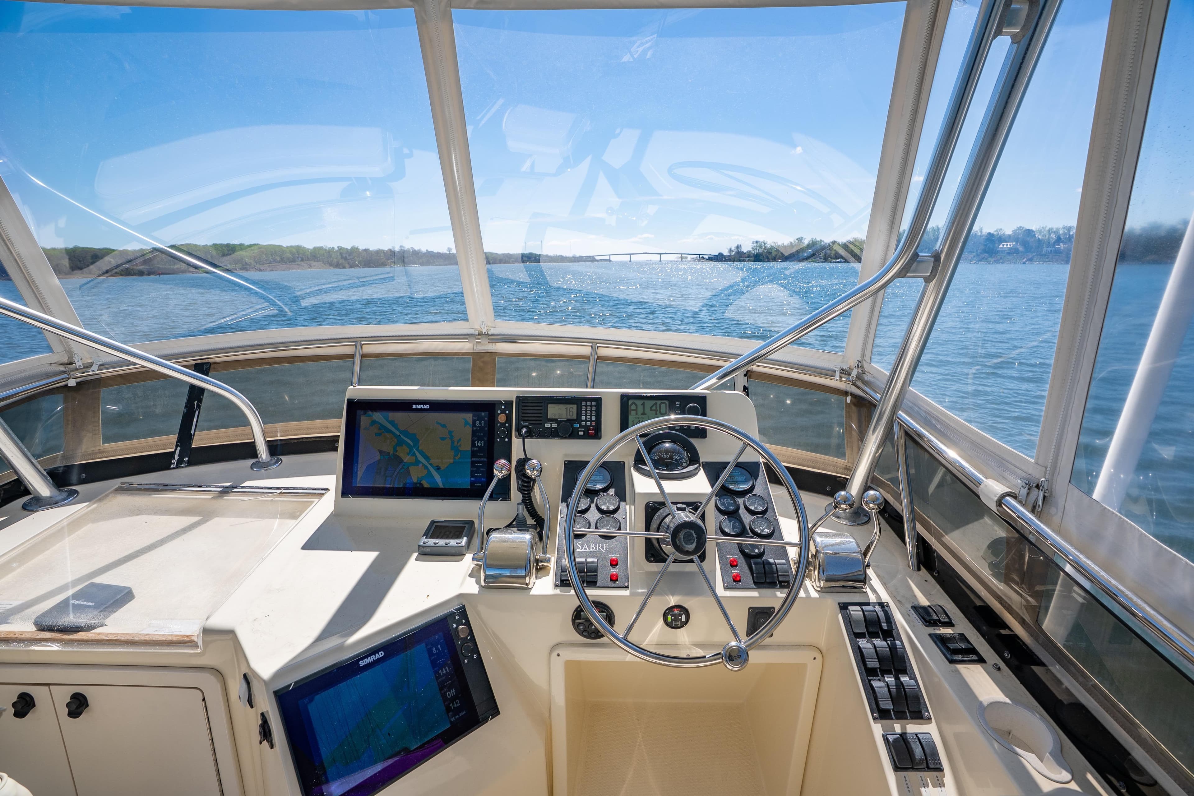Cockpit view of 2006 Sabreline 36 Fly yacht, featuring navigation equipment and steering wheel.