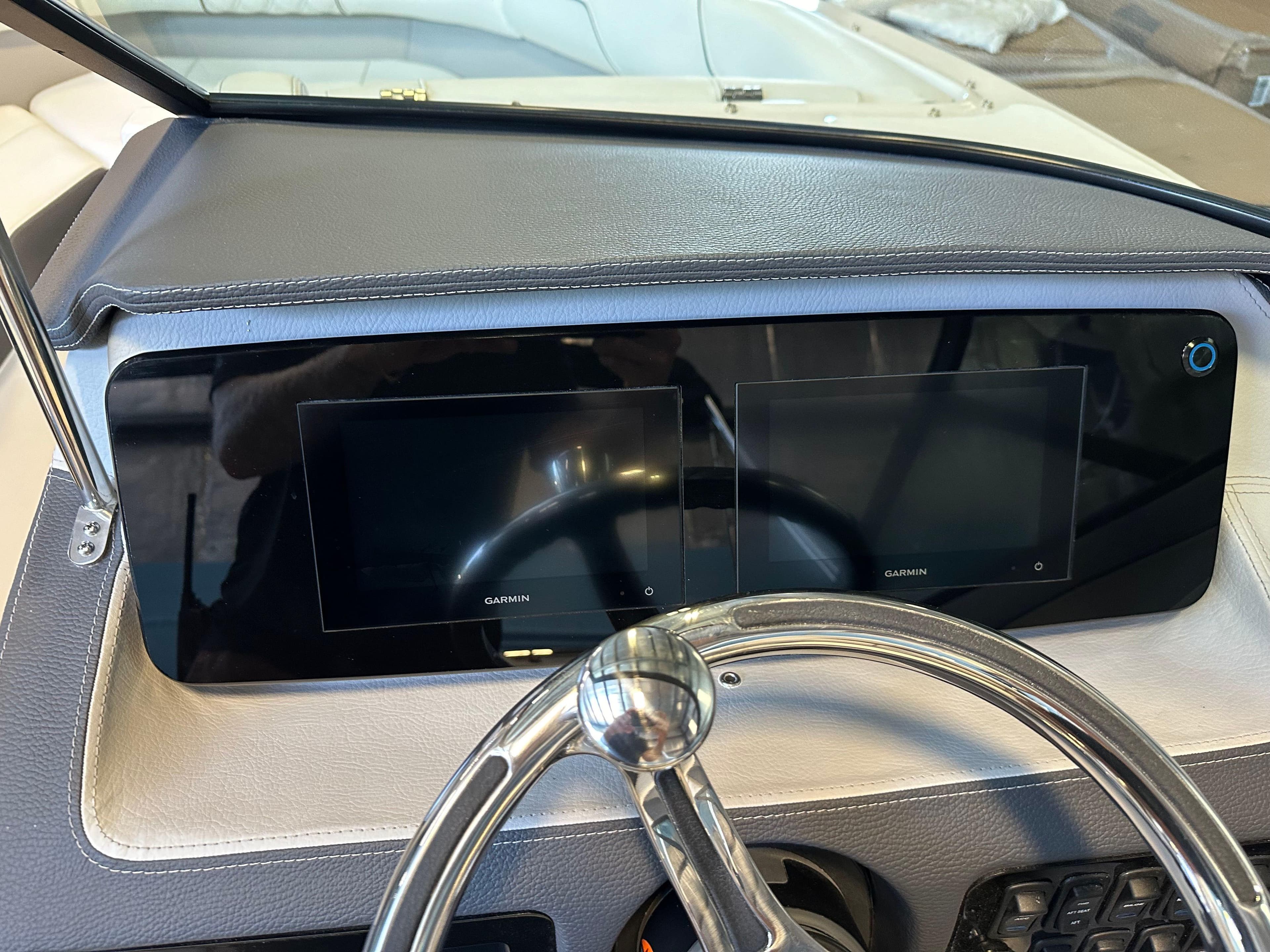 Dashboard of 2025 Regal LX2 boat with dual Garmin displays and steering wheel.
