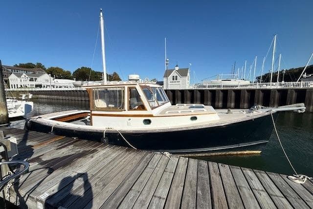 1975 Jarvis Newman 32 DEC boat docked at a marina under clear blue skies.