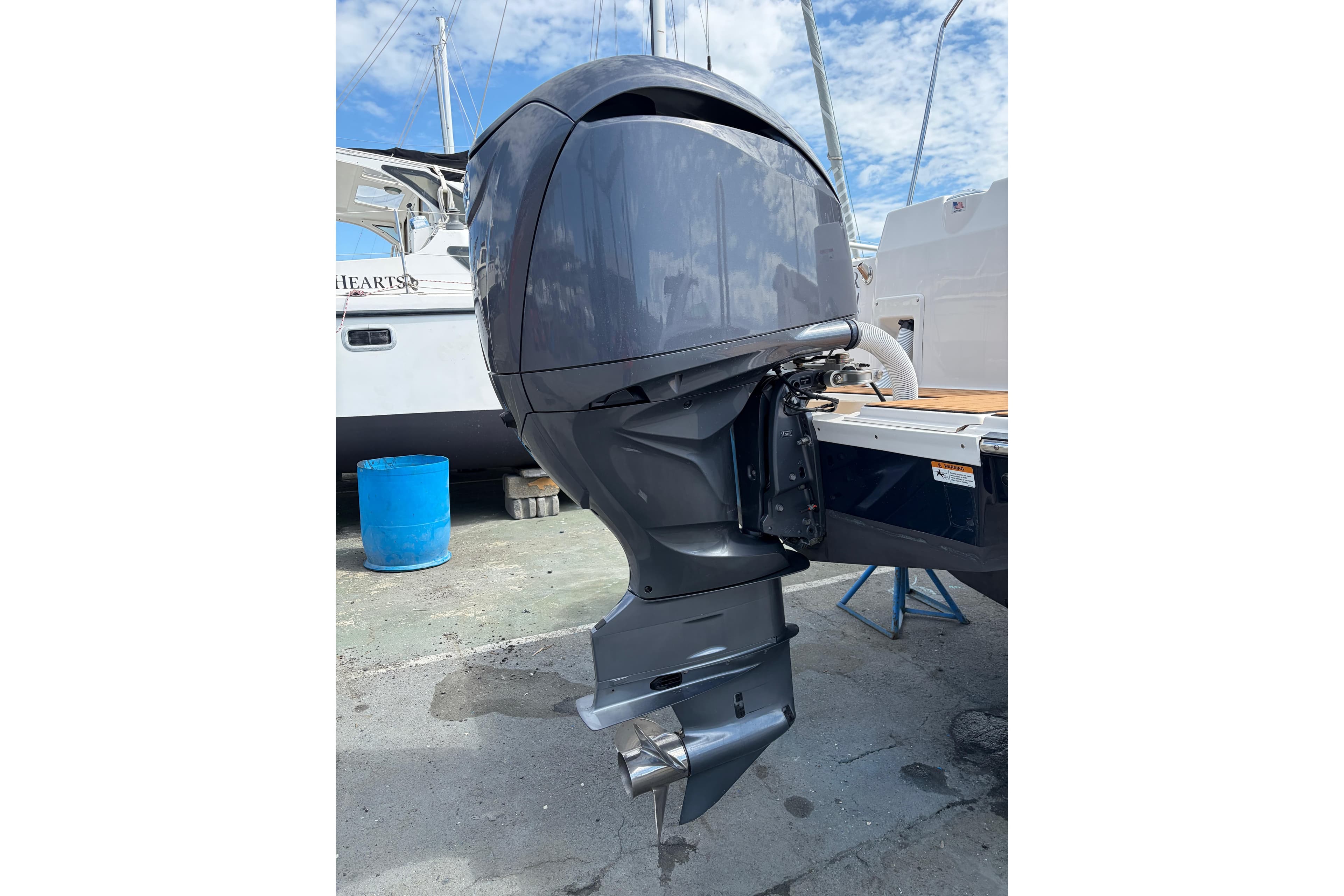 2022 Ranger Tugs R-27 outboard motor, docked, with blue sky background.