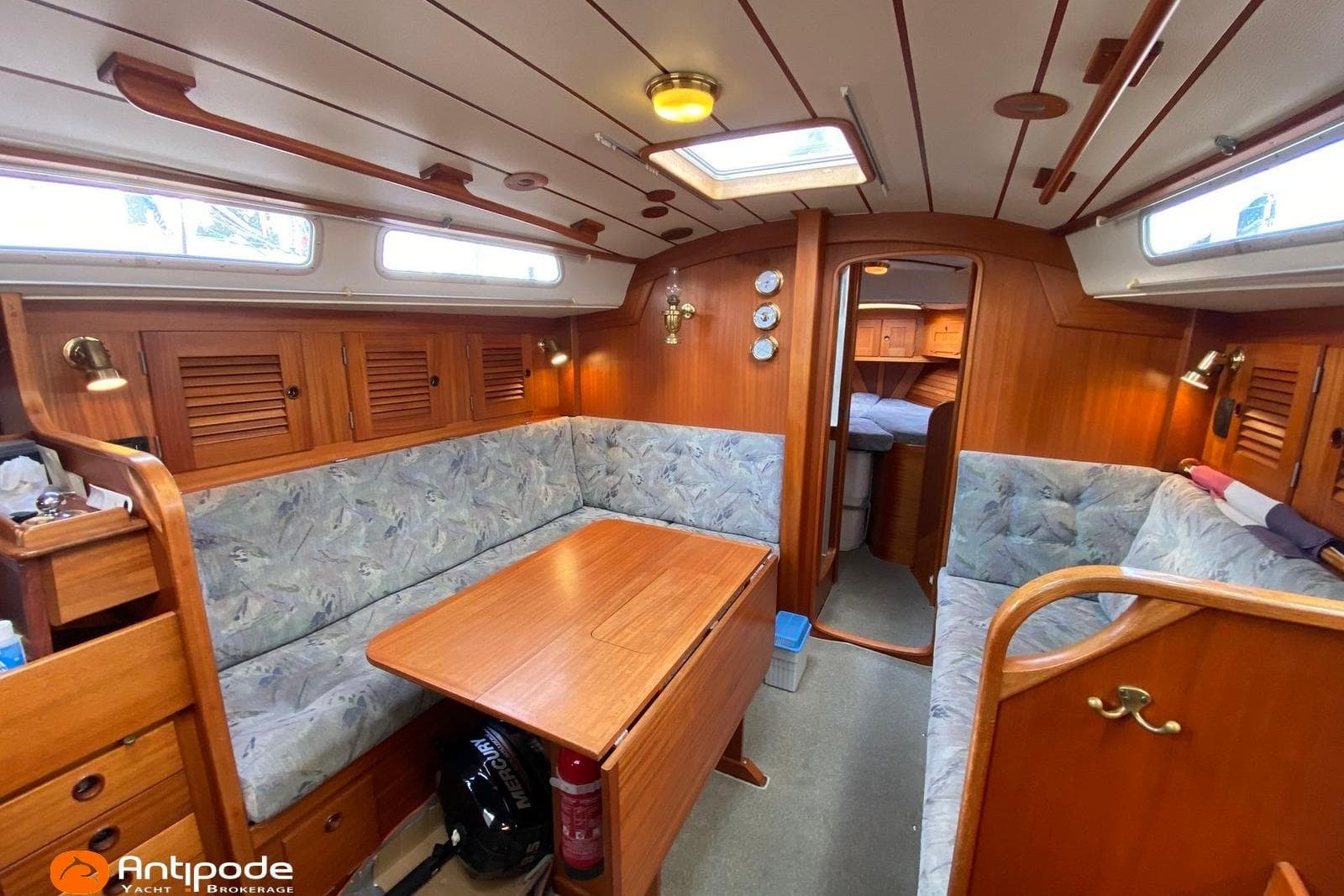 Interior of a 1992 Hallberg-Rassy 36 yacht with cozy seating and wooden finishes.