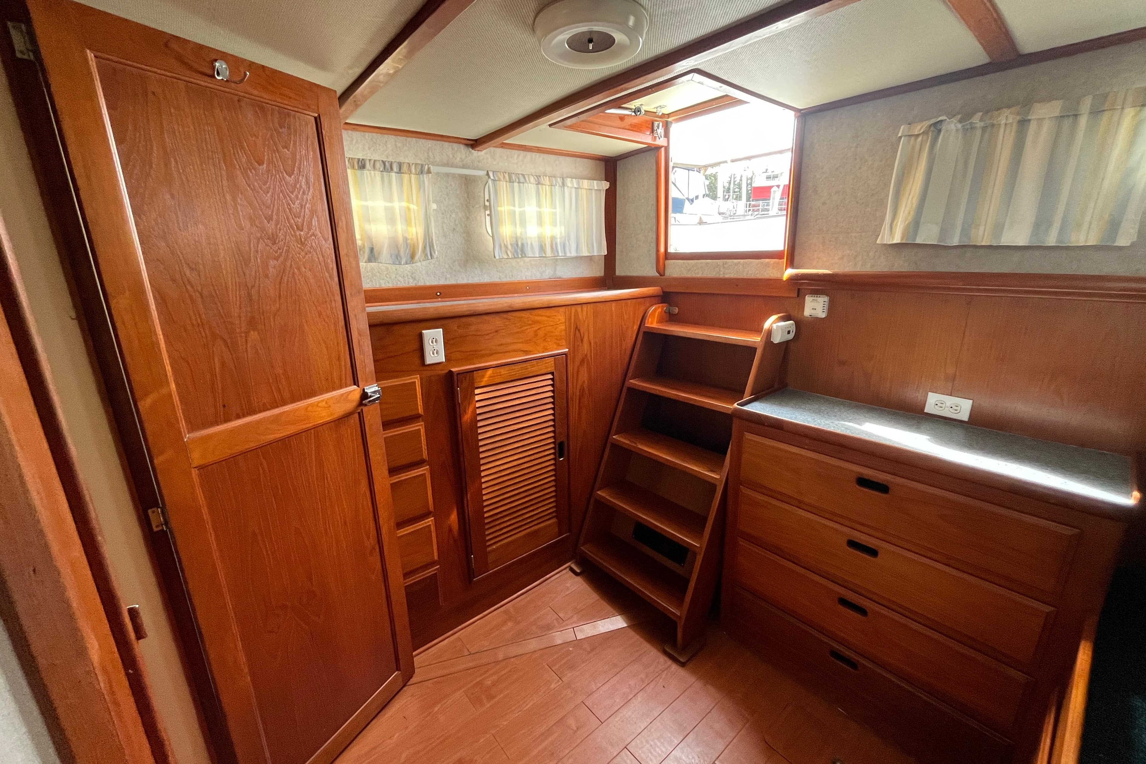 1974 DeFever 40 interior with wooden cabinetry, stairs, and natural light.