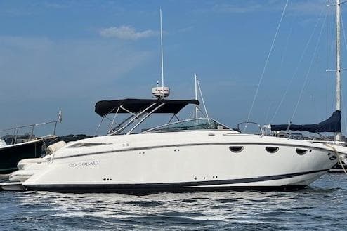 2008 Cobalt 323 boat on water, white exterior, black canopy, clear sky background.