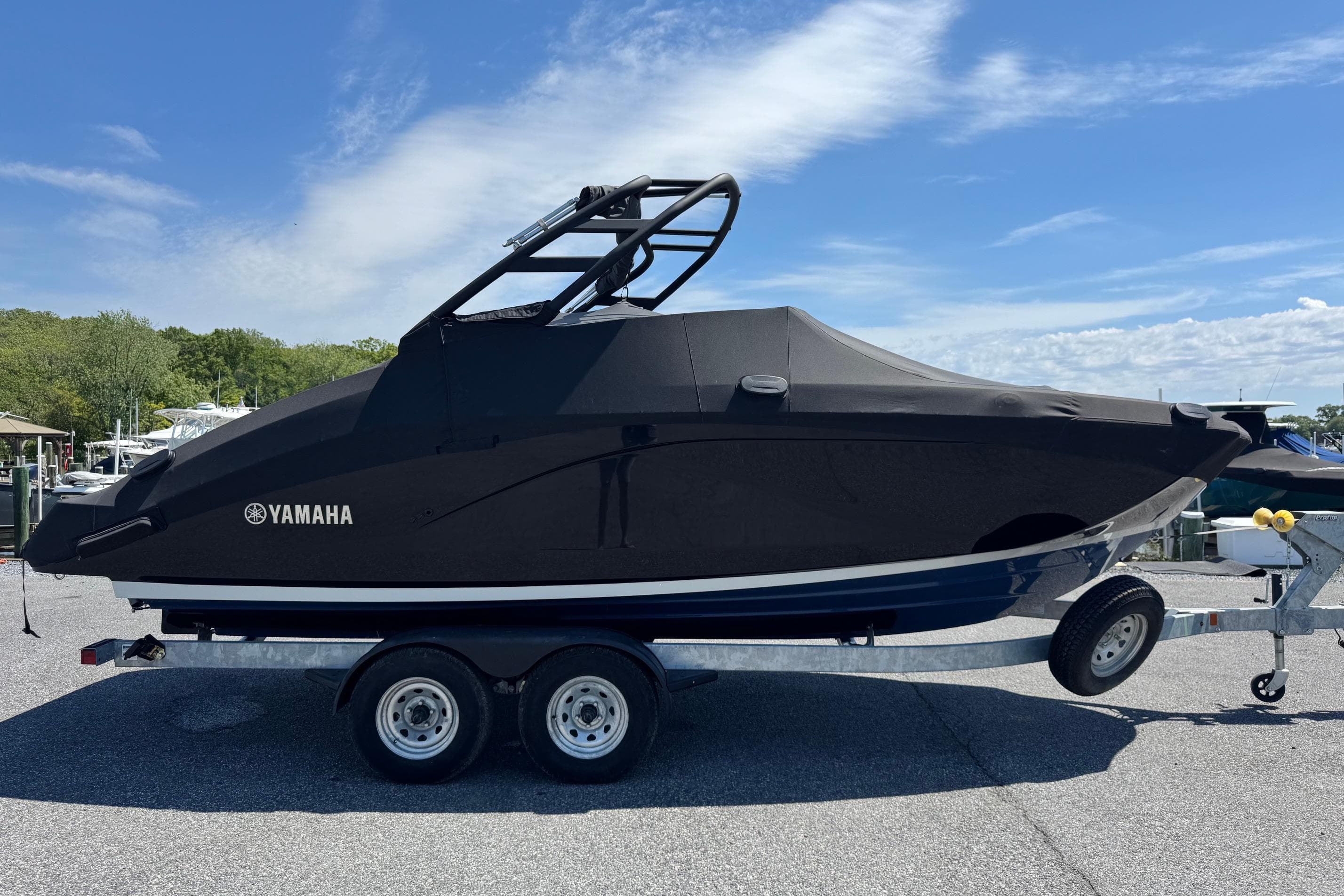 2023 Yamaha Boats 222SD covered on trailer, parked outdoors under blue sky.